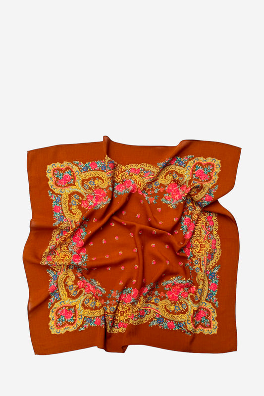 Rust-colored square scarf featuring a decorative gold, blue, and pink floral chain border and tiny flower accents.