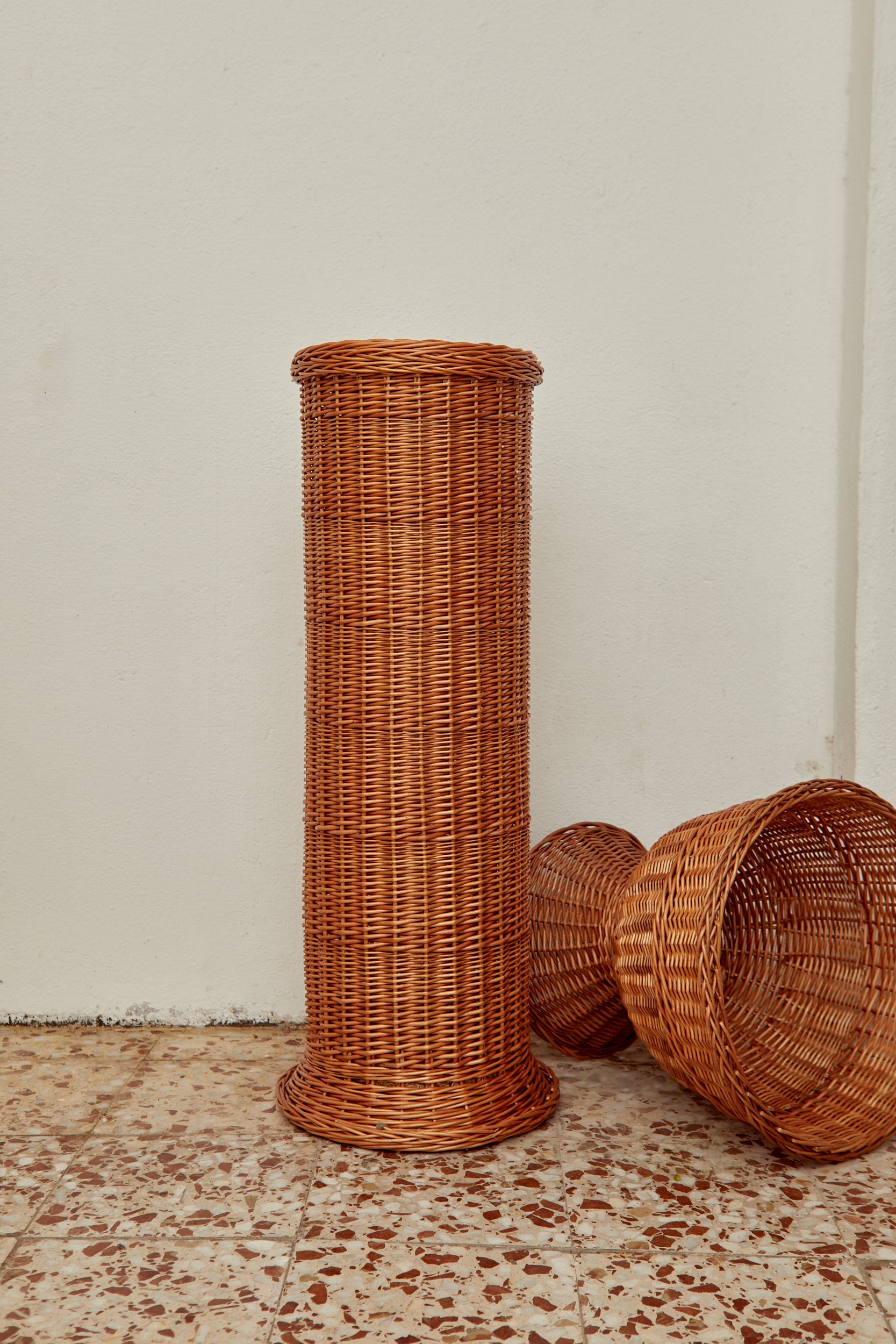 Cesta alta de mimbre marrón, estilo contemporáneo, ideal para almacenamiento y decoración moderna.