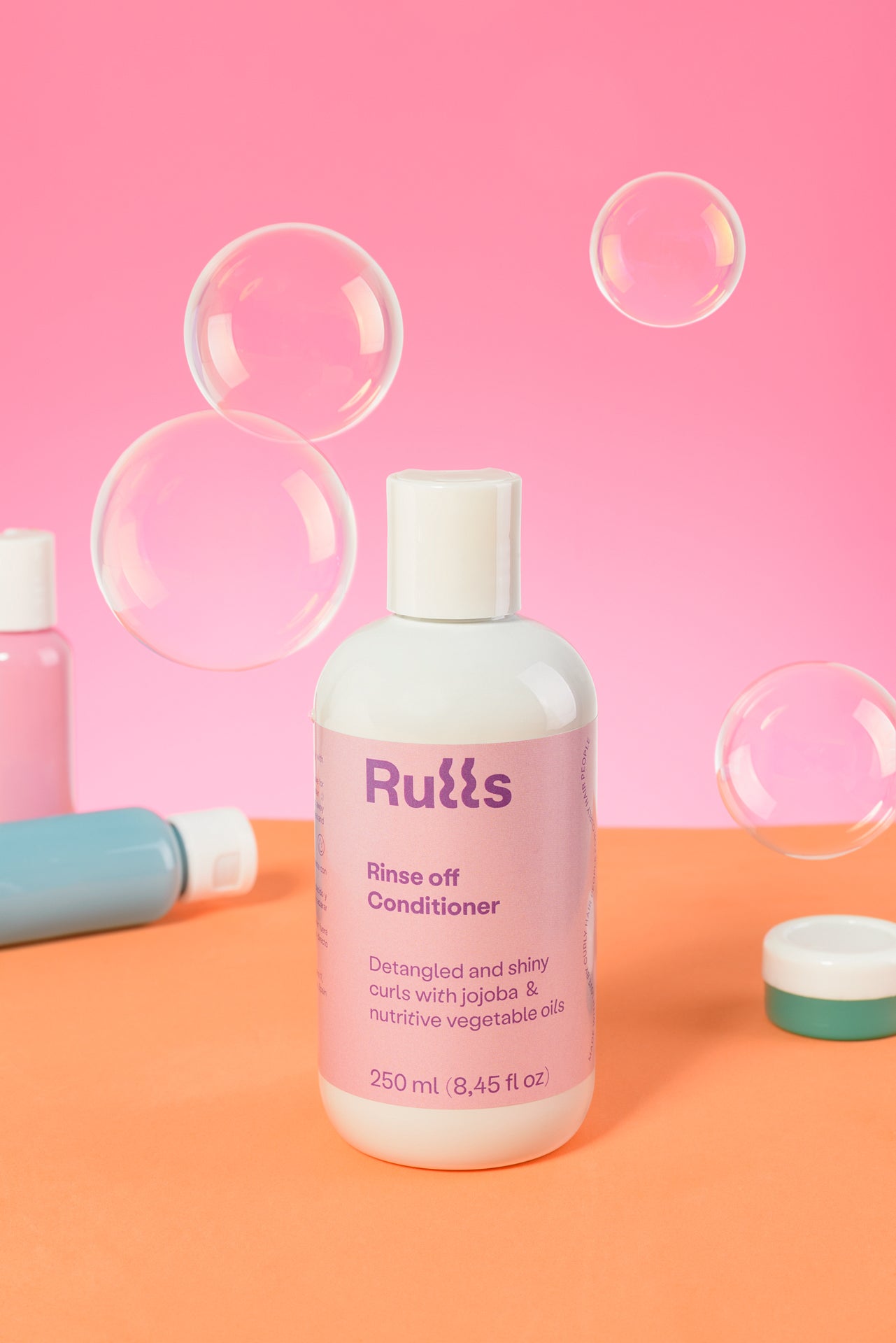 Acondicionador de 250 ml en frasco blanco con etiqueta morada para rizos desenredados y brillantes.