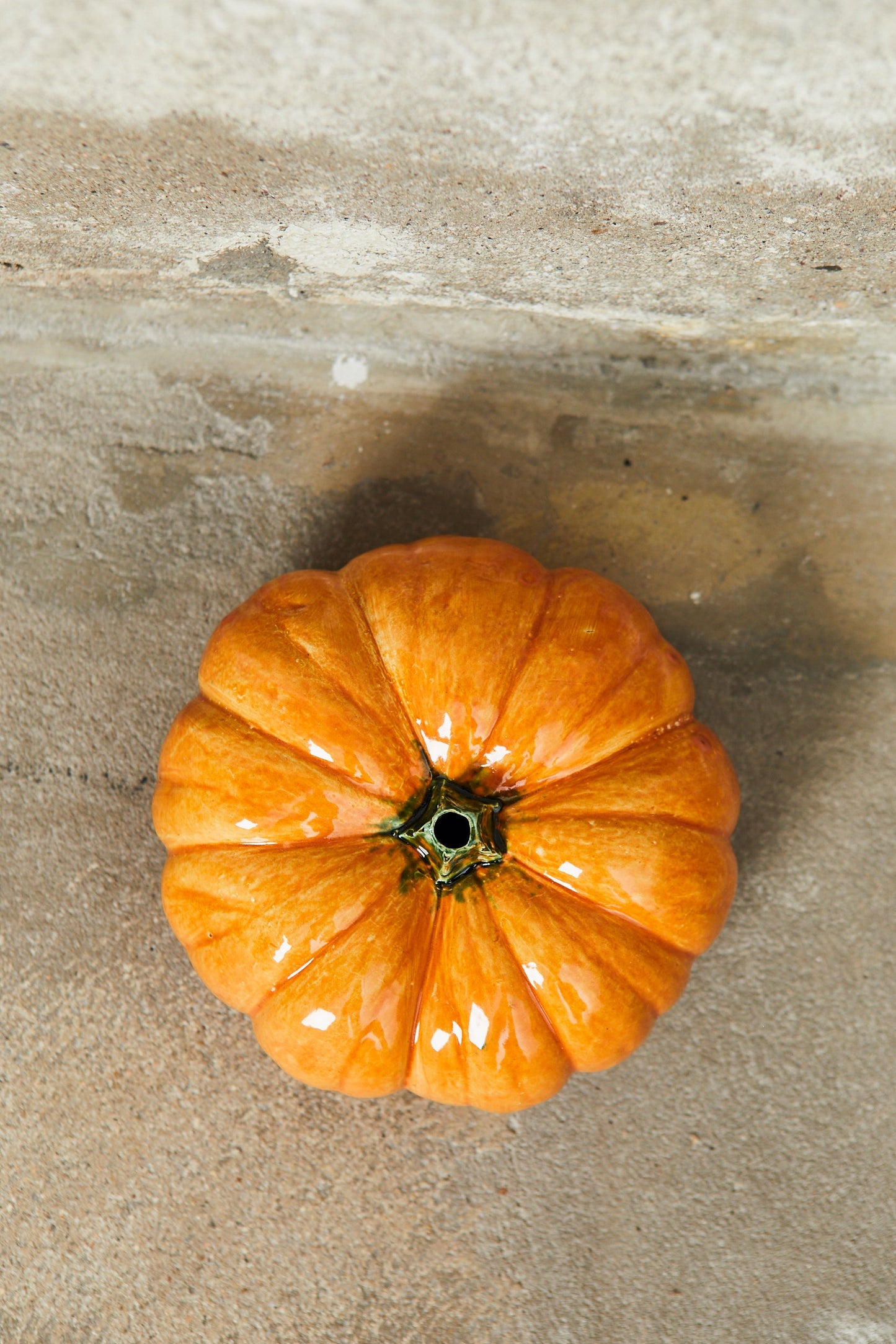Calabaza anaranjada brillante de cerámica, con diseño clásico y textura lisa, ideal para decoración de otoño.