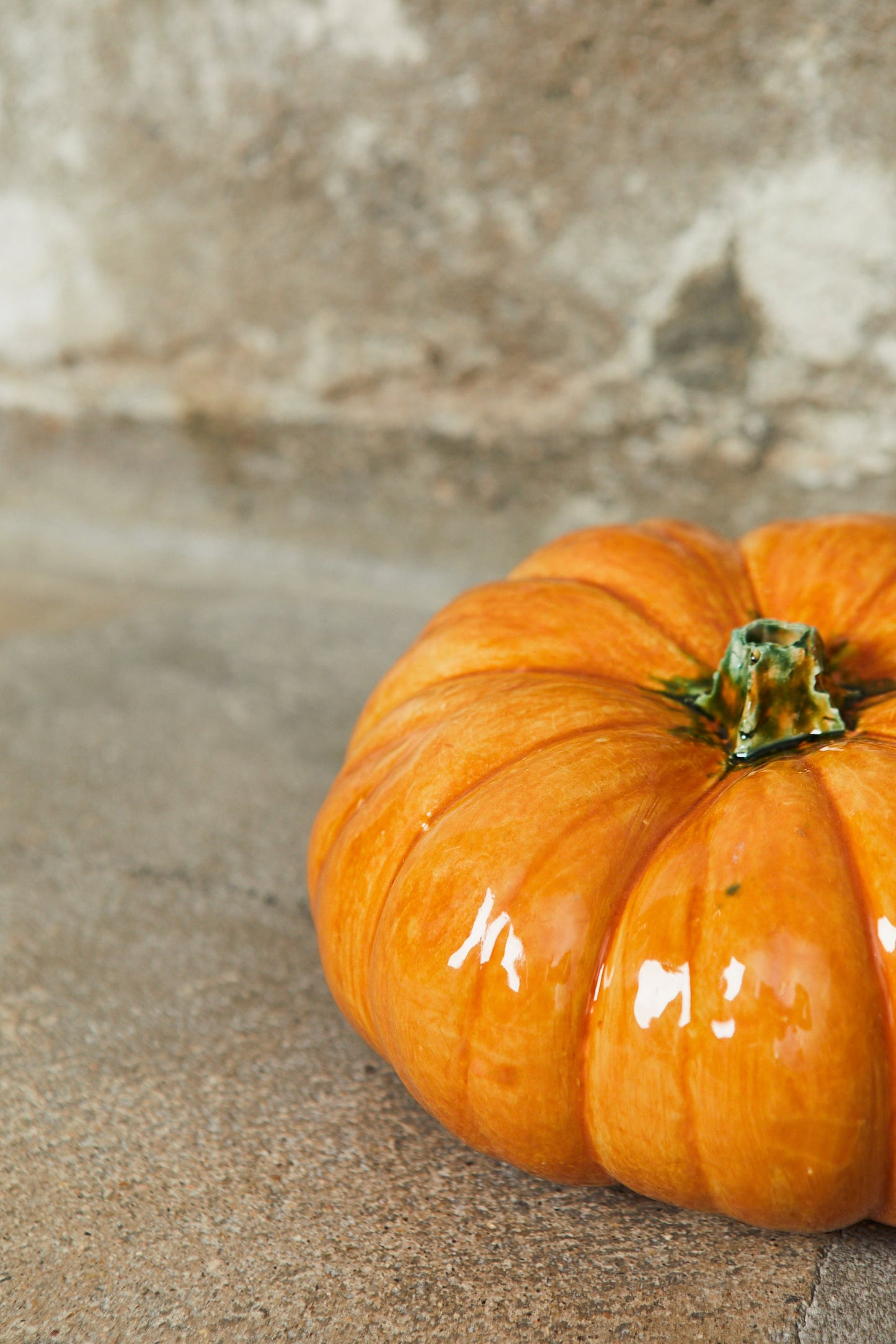 Calabaza de cerámica brillante color naranja, con detalles verdes, ideal para decoración de otoño.