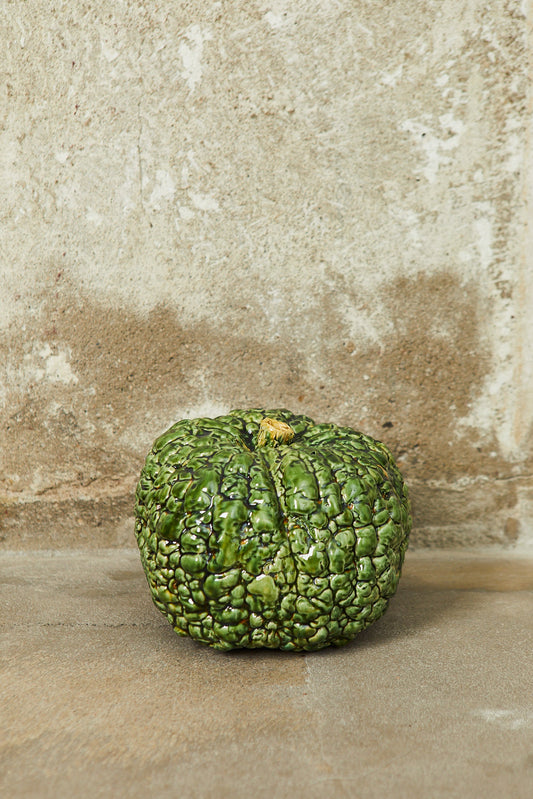 Calabaza verde brillante de cerámica con textura rugosa, ideal para decoración y estilo rústico.