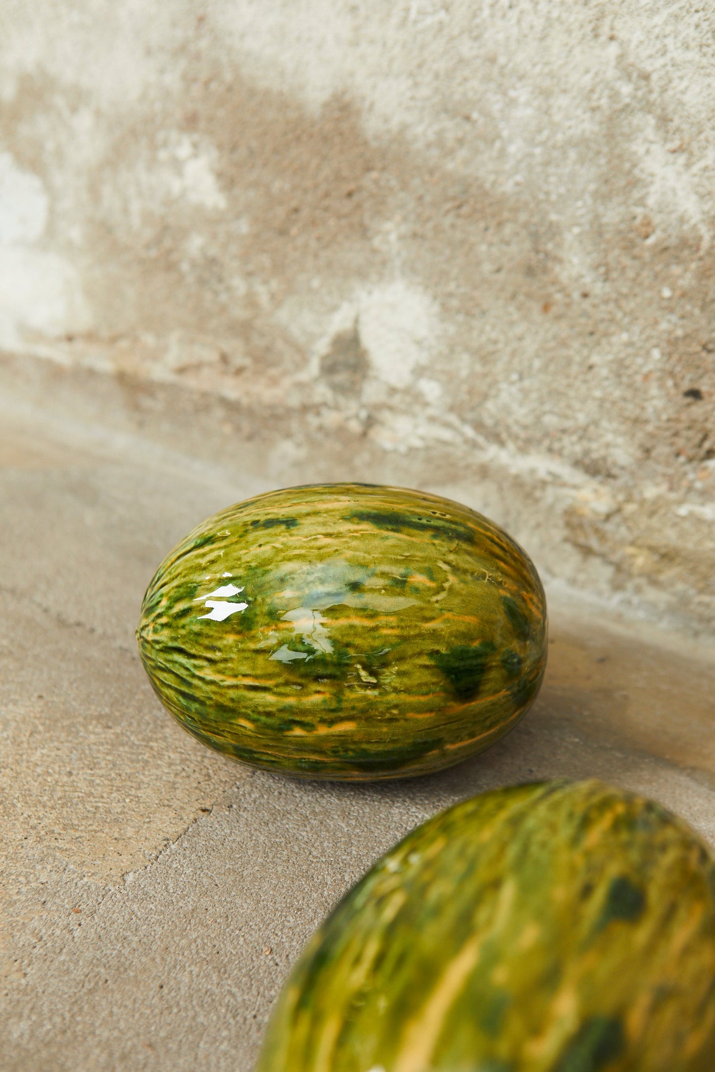 Sandía de cerámica verde y amarilla, estilo moderno, decorativa y resistente, ideal para interiores.