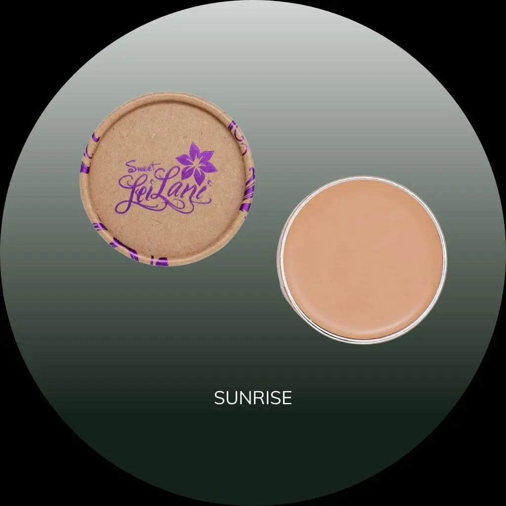 Sweet LeiLani circular cardboard compact with lid open next to Sunrise shade concealer on a dark gradient background.