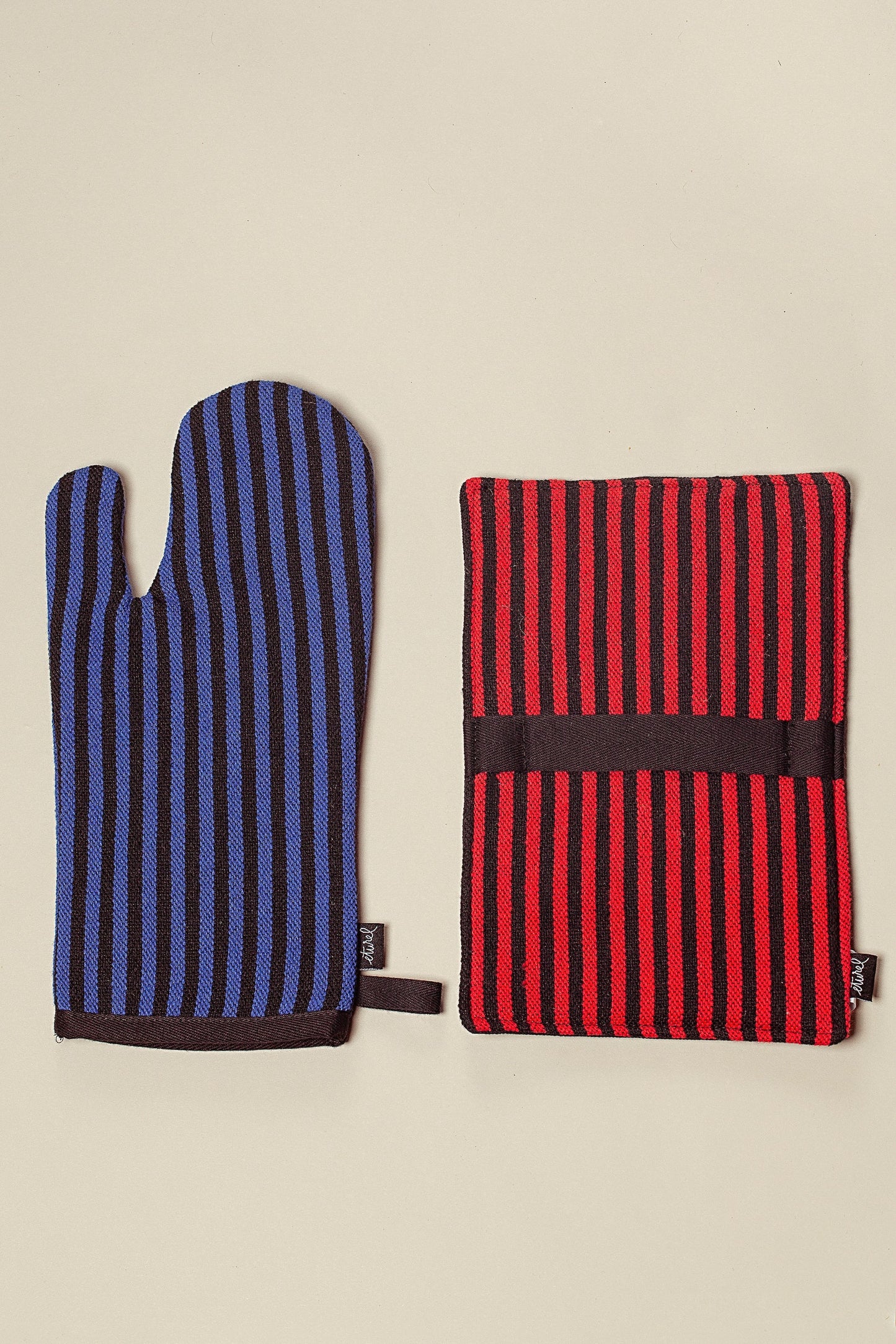 Guante y agarradera de cocina a rayas, azul y negro el guante, rojo y negro la agarradera, estilo moderno y funcional.