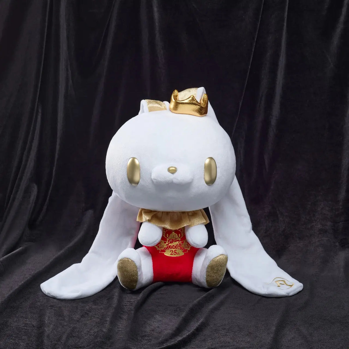 White Chax bunny plush with gold eyes, crown, and accents, wearing a red "Gloomy 25th" chest piece on a black backdrop.
