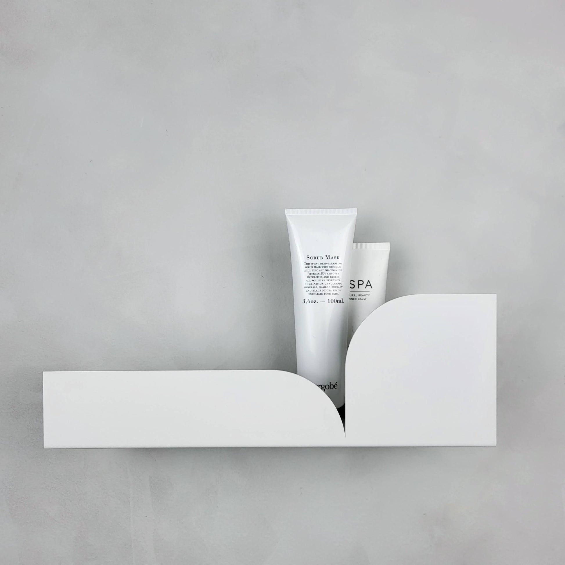 Estantería metálica mediana Torino con productos de spa decorando una pared moderna.