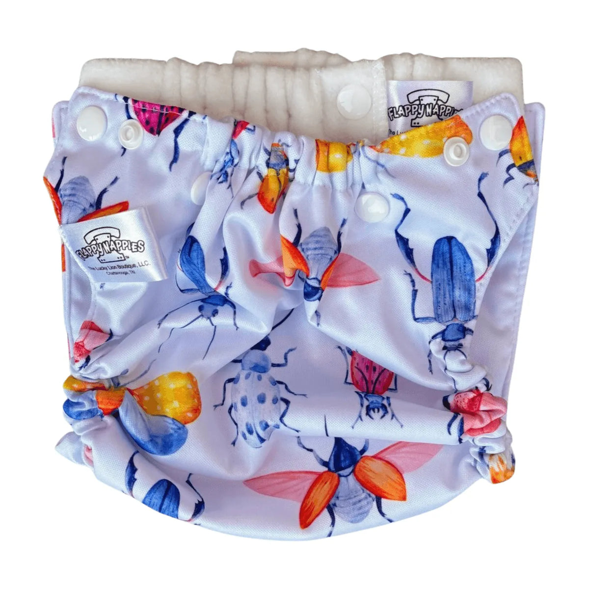 White diaper cover with colorful beetle print, snap closures, and a soft, gathered interior lining.