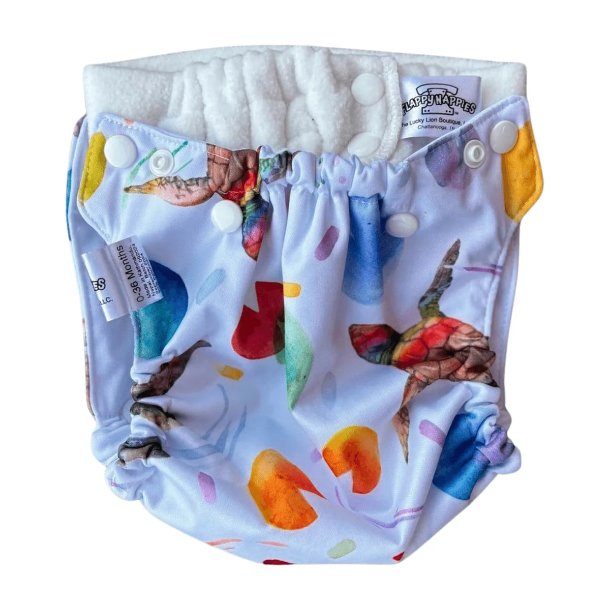All-in-two diaper cover with colorful sea turtle print, white fleece lining, and snap closures on white fabric.