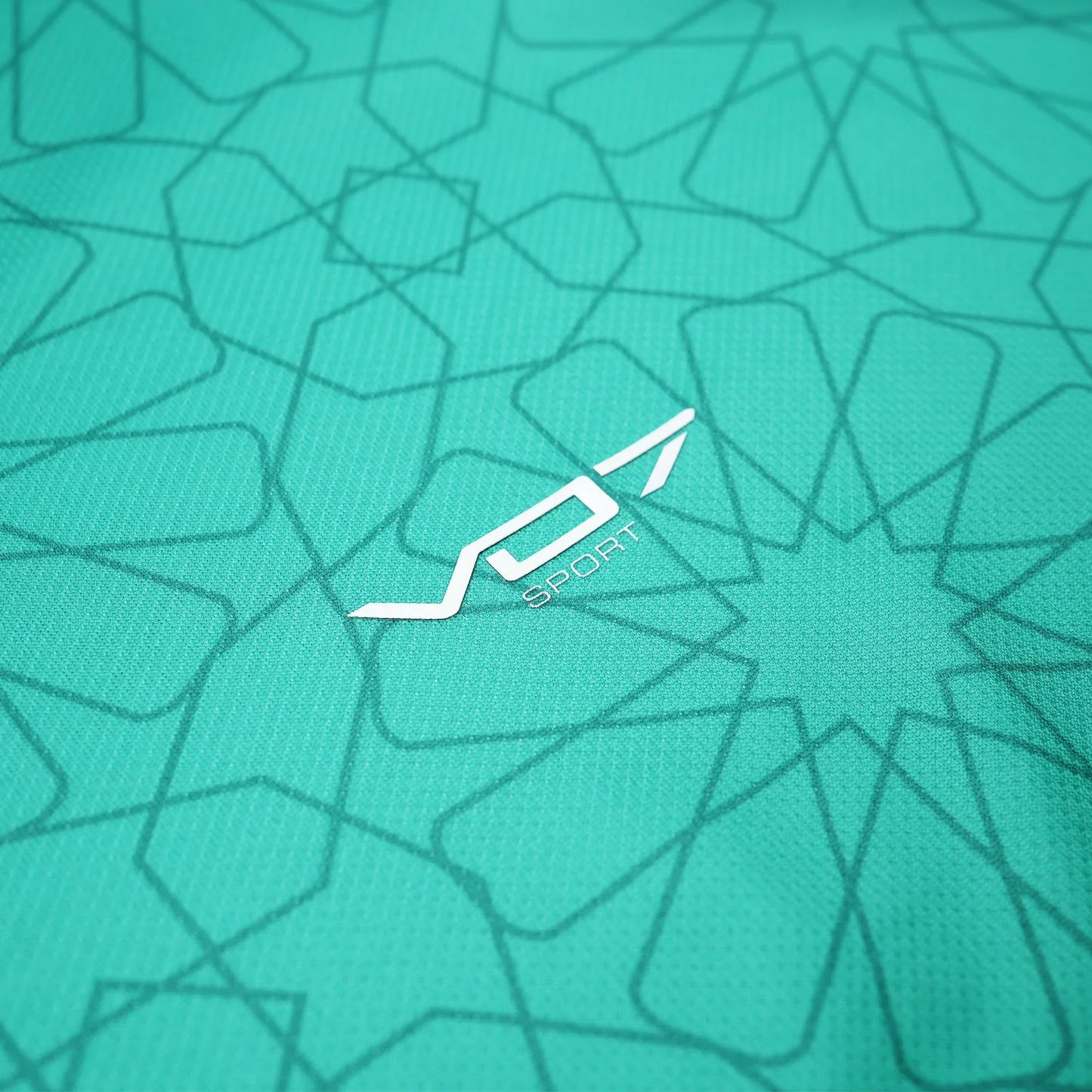 Maillot VO7 vert à motifs géométriques traditionnels et logo blanc contrastant, sur tissu technique texturé.