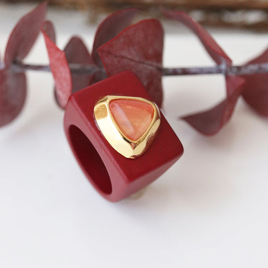 Anillo cuadrado rojo con piedra triangular naranja y detalles en oro. Ideal para un estilo moderno y elegante.