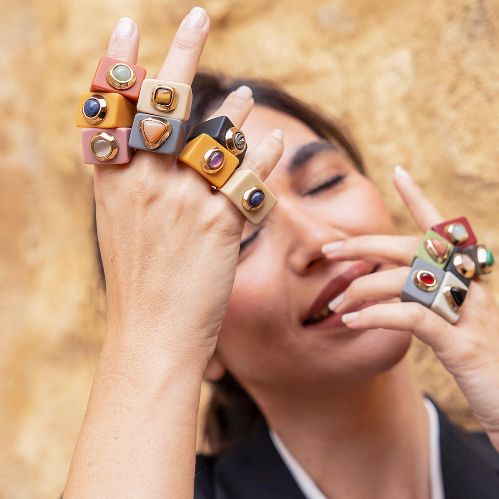 Anillos modernos de resina mate en tonos naranja, negro, gris y rosa con piedras decorativas. Ideal para un estilo chic.