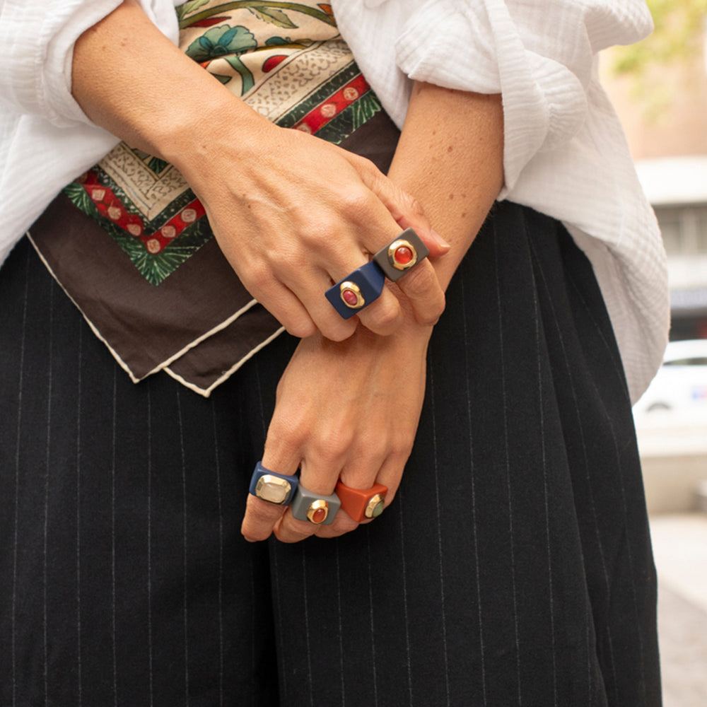 Anillos de colores azul, naranja y dorado, con diseño moderno y elegante, perfectos para cualquier ocasión.