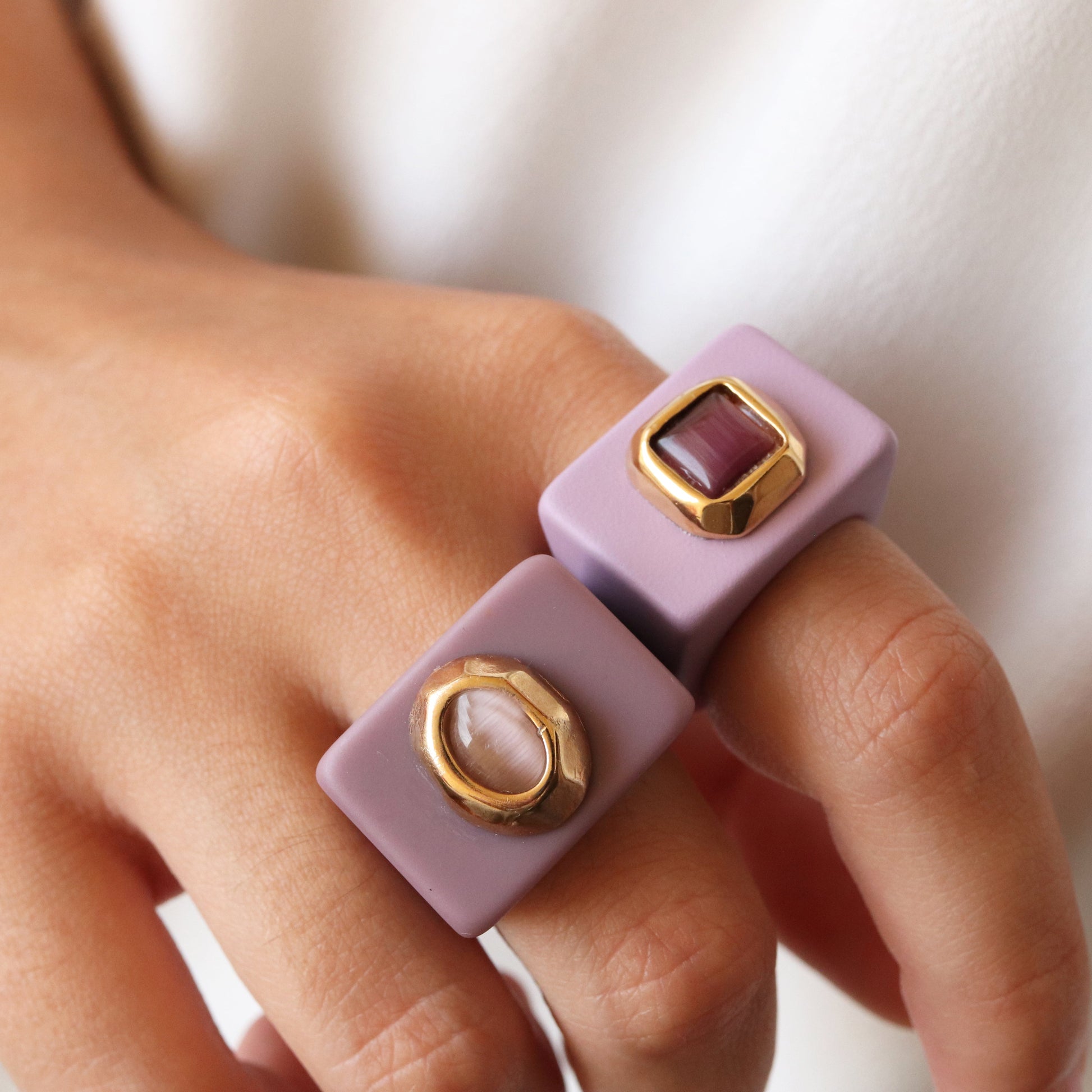 Anillos cuadrados de resina morada con detalles dorados, estilo moderno y minimalista, perfectos para cualquier ocasión.