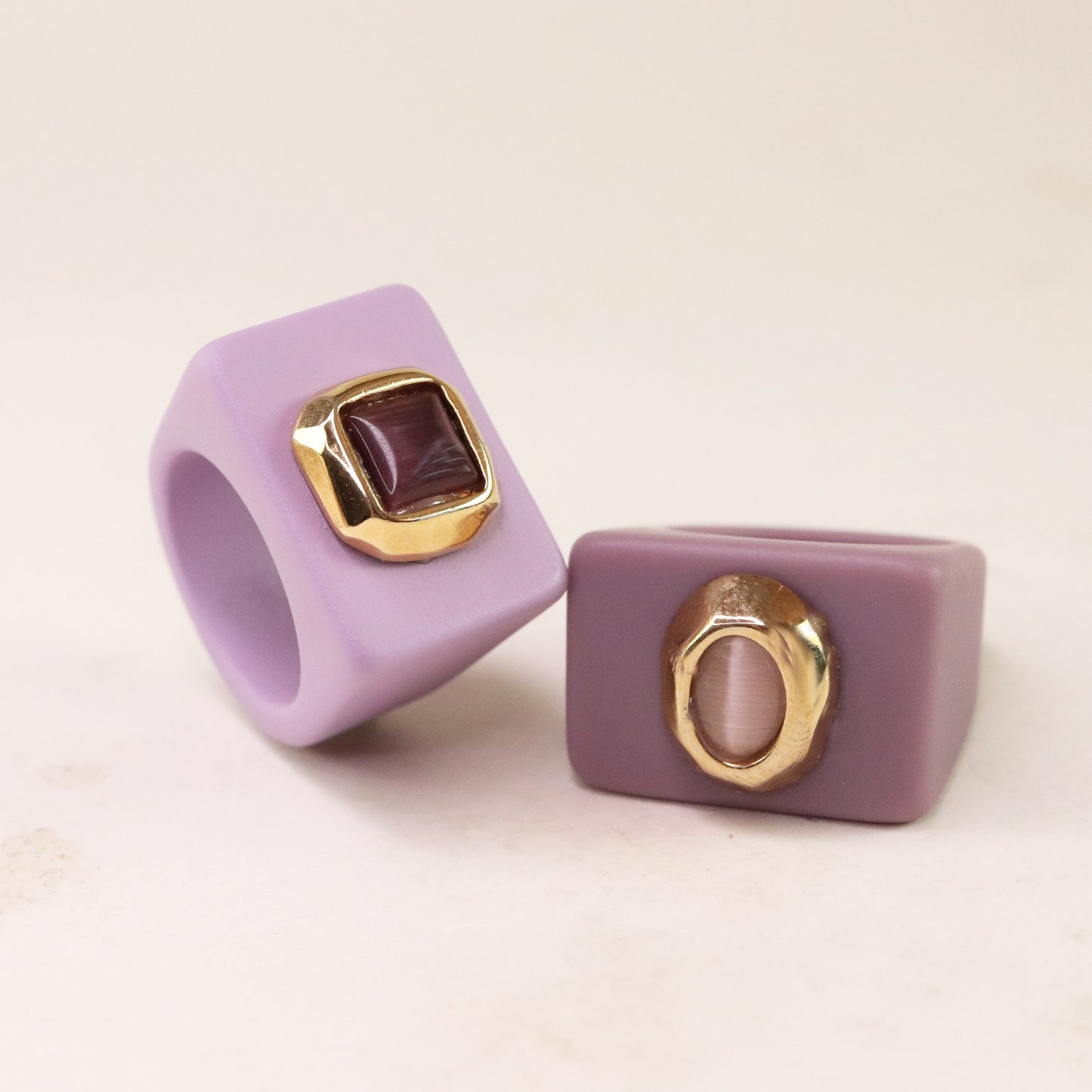 Anillo cuadrado morado de silicona con detalles dorados y gemas, elegante y moderno.