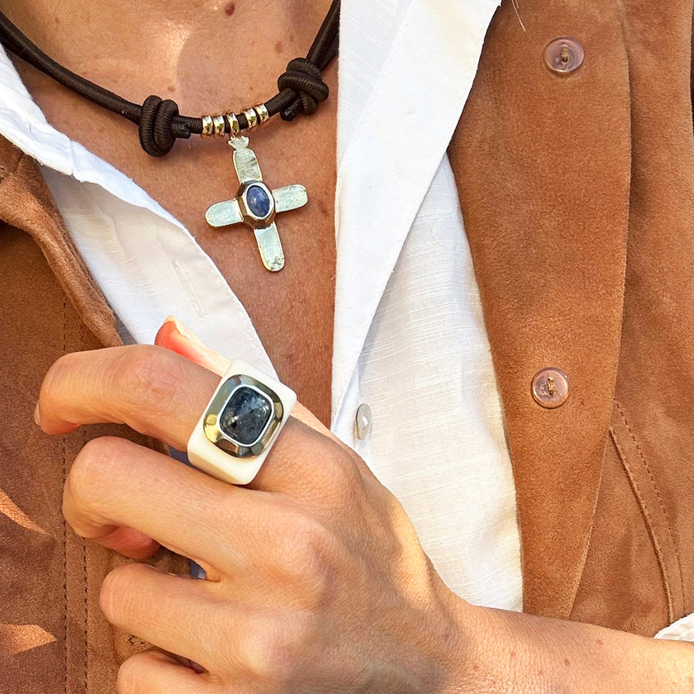 Collar de cruz dorada con piedra azul y anillo cuadrado blanco y azul, estilo bohemio y artesanal.
