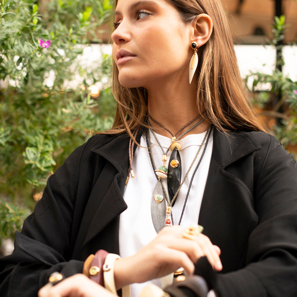 Collar y aretes de diseño elegante en tonos dorados y verdes, con detalles en madera y cuero, estilo bohemio.