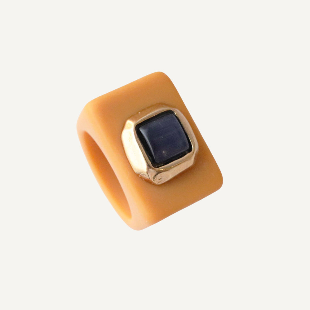 Anillo de silicona naranja con piedra azul, diseño moderno y elegante. Ideal para un estilo contemporáneo.