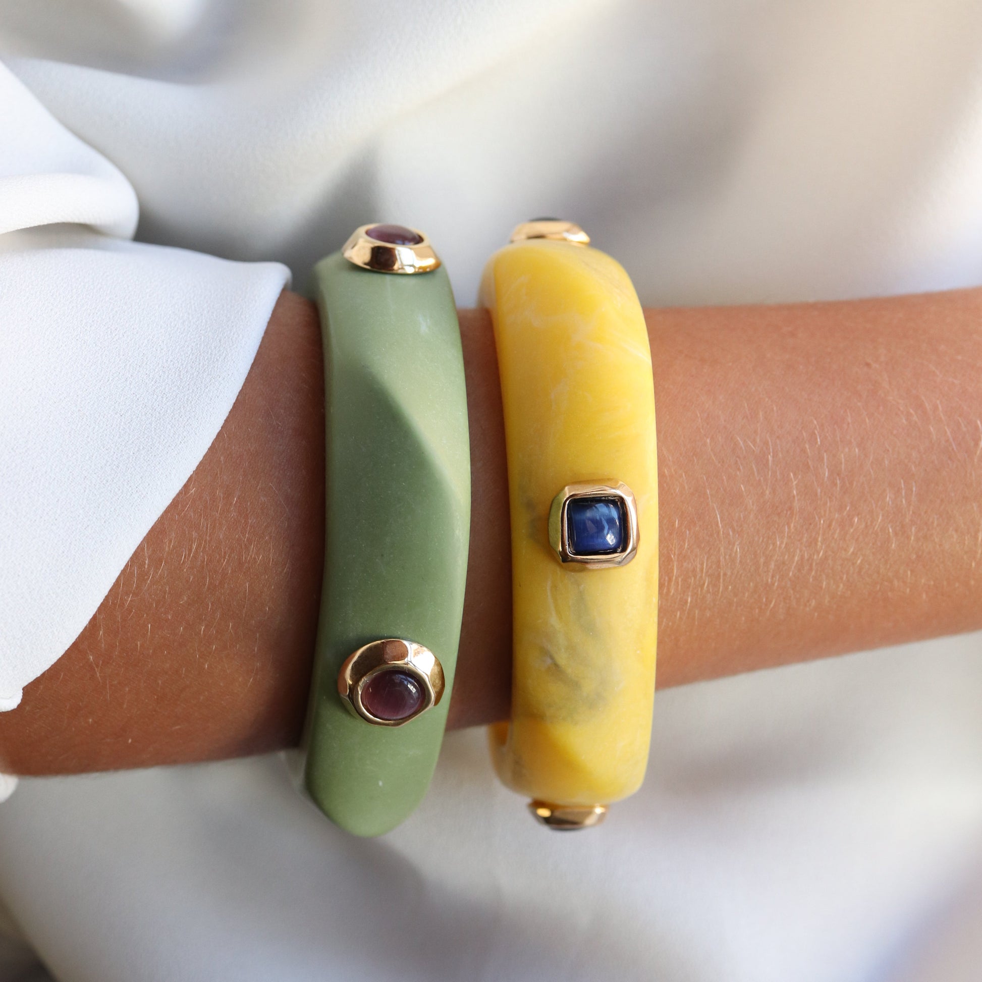 Pulseras de silicona verde y amarilla con detalles dorados y piedras preciosas, estilo moderno y elegante.