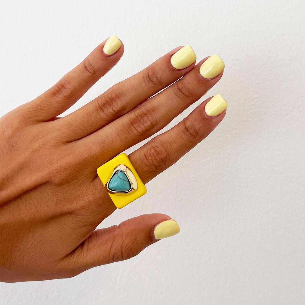 Anillo cuadrado amarillo con piedra turquesa, estilo moderno, ideal para verano.