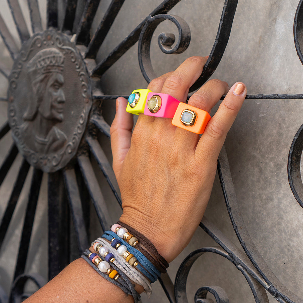 Anillo de resina en colores neón con detalles de piedra, estilo moderno y divertido.