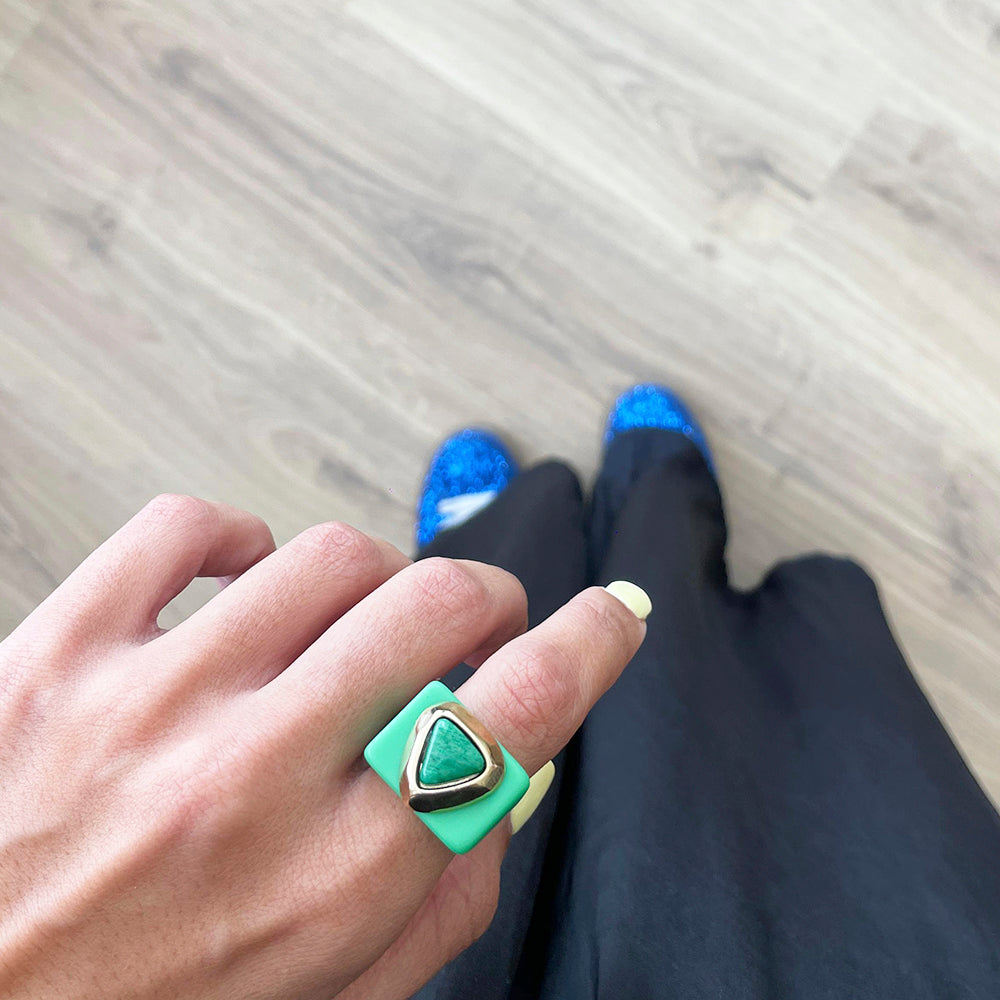 Anillo cuadrado verde con piedra triangular, estilo moderno, ideal para un look elegante.