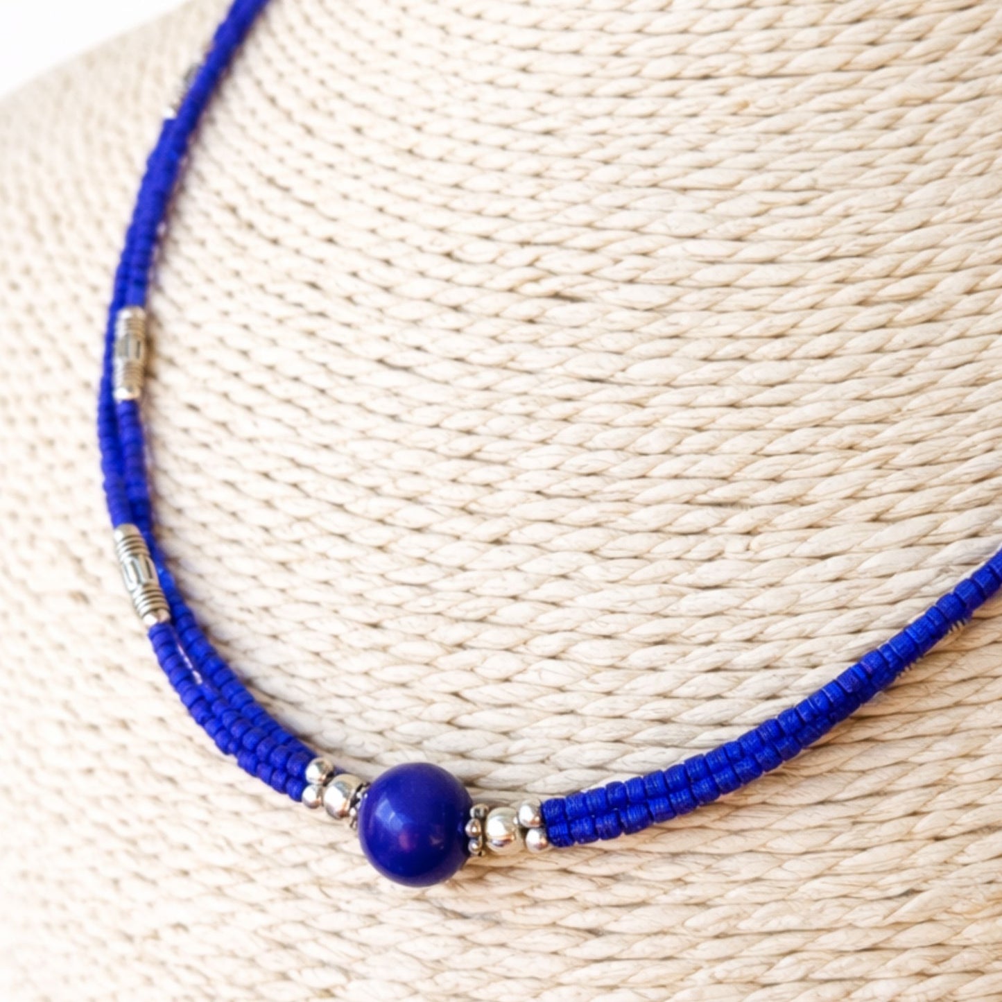 Collar de cuentas azules y plateadas con piedra central, estilo bohemio, material de cerámica y metal.