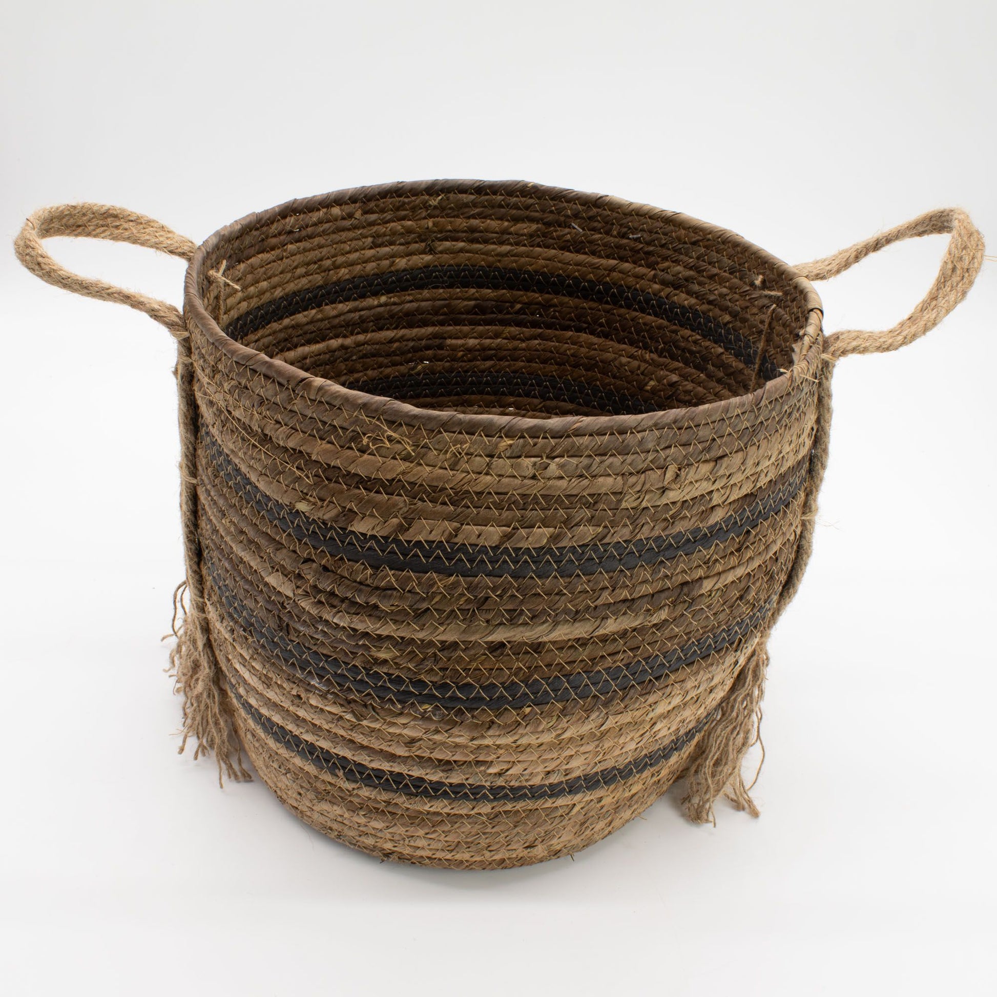 Cesta artesanal de fibras naturales tejidas en tonos marrón, con diseño de rayas oscuras y asas laterales de cuerda.