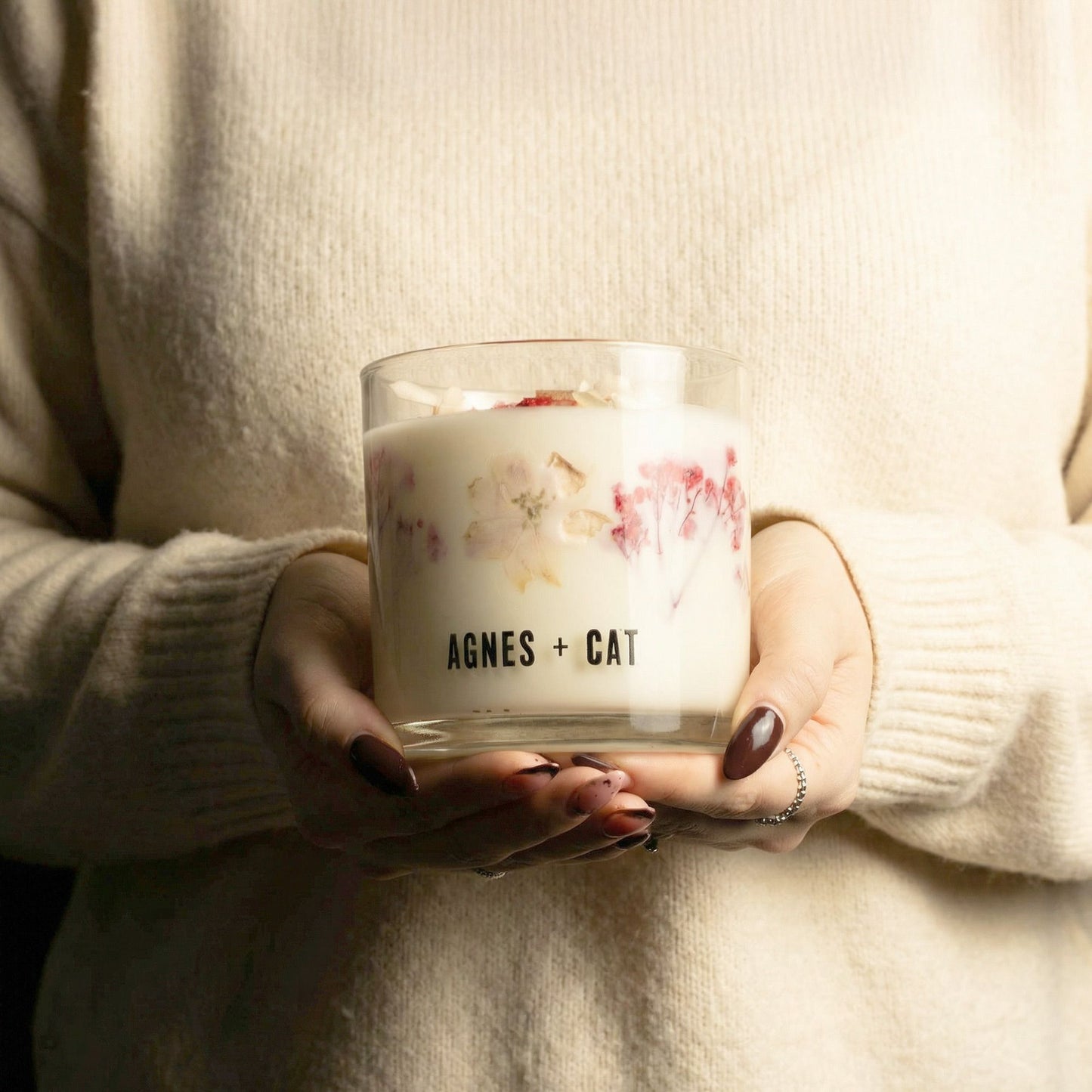 Vela aromática de cera natural con flores secas en vaso de vidrio, marca Agnes + Cat, estilo elegante y moderno.
