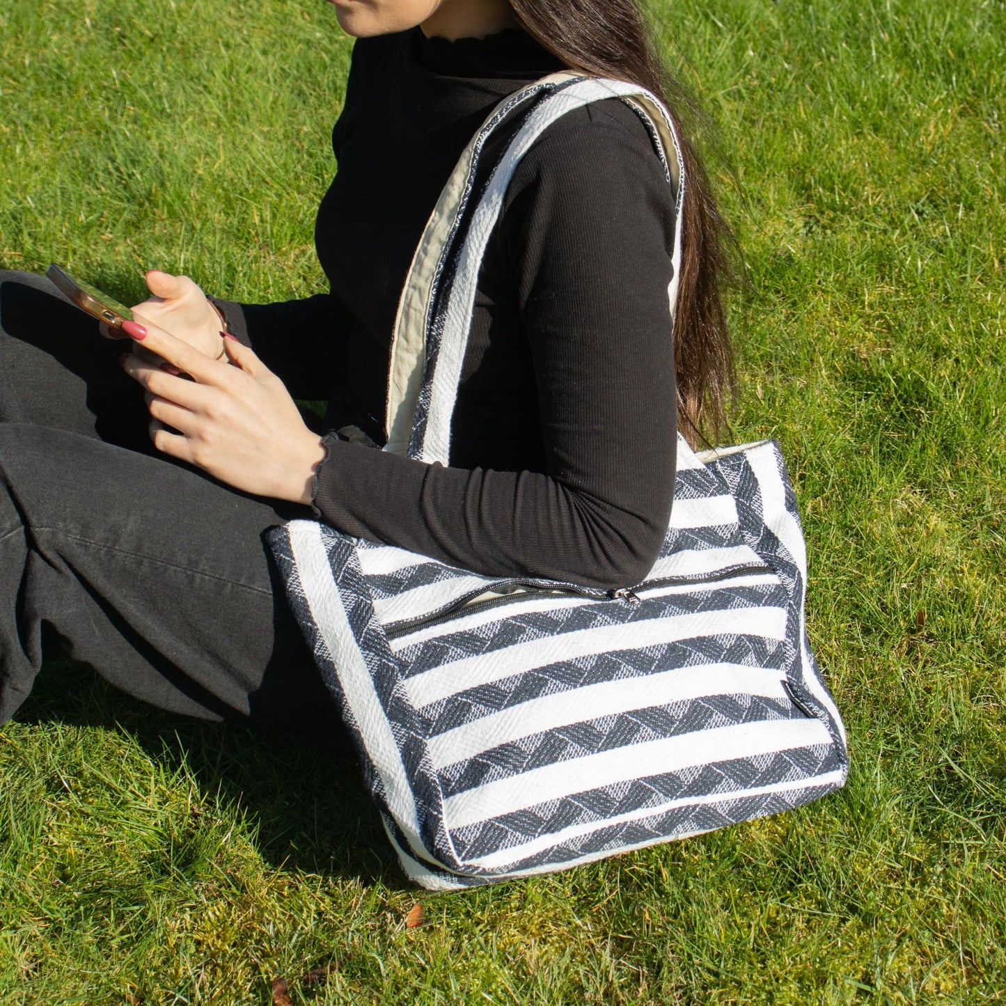 Bolso de tela negro y blanco con rayas, estilo casual, ideal para uso diario, material resistente.