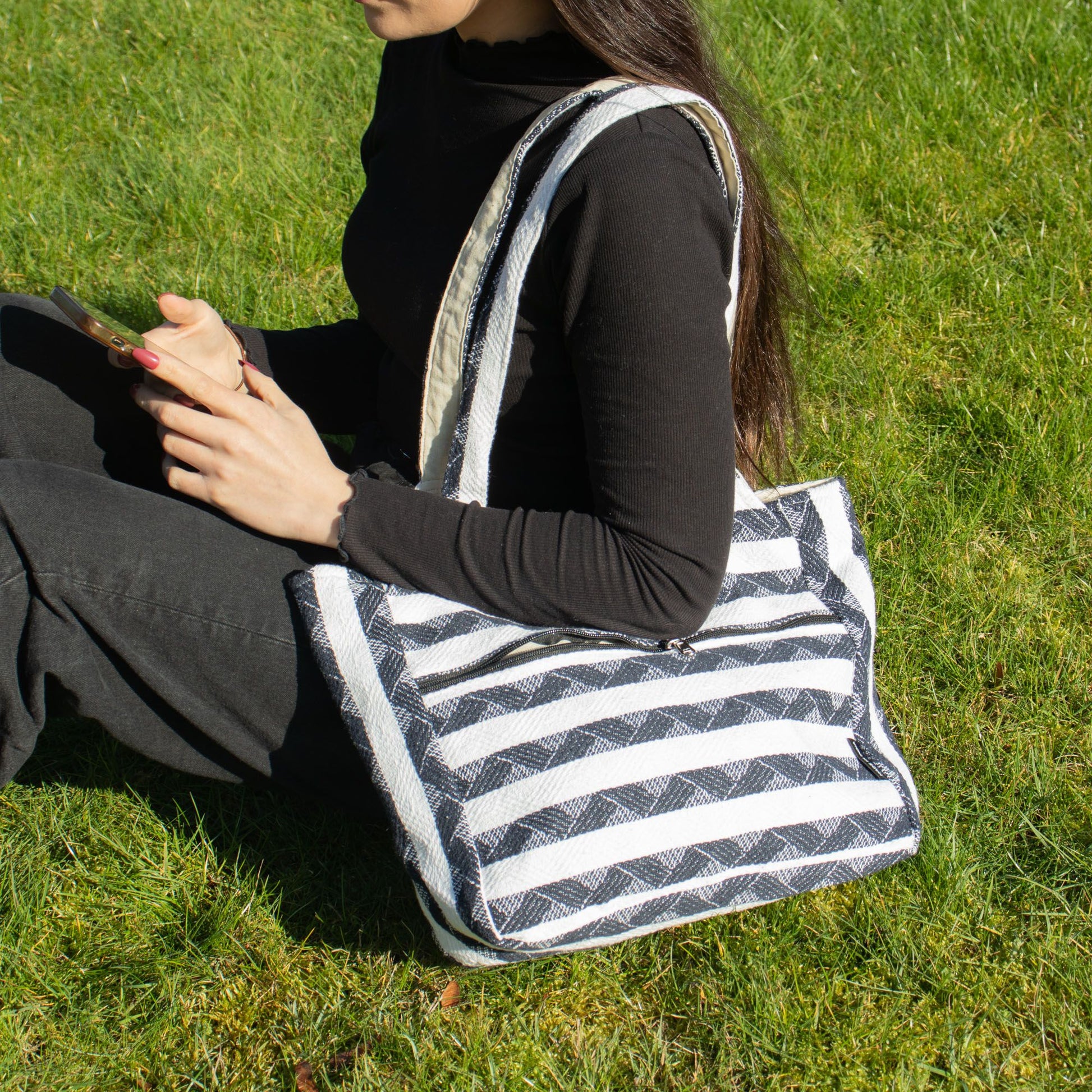 Bolso de tela negro y blanco con rayas, estilo casual, ideal para uso diario, material resistente.