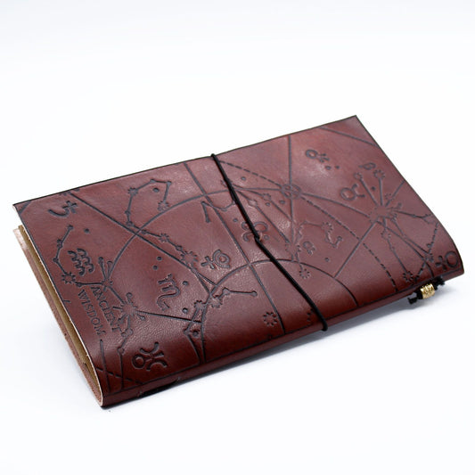 Cuaderno de cuero marrón con estampado de constelaciones, estilo vintage, ideal para journaling o notas.
