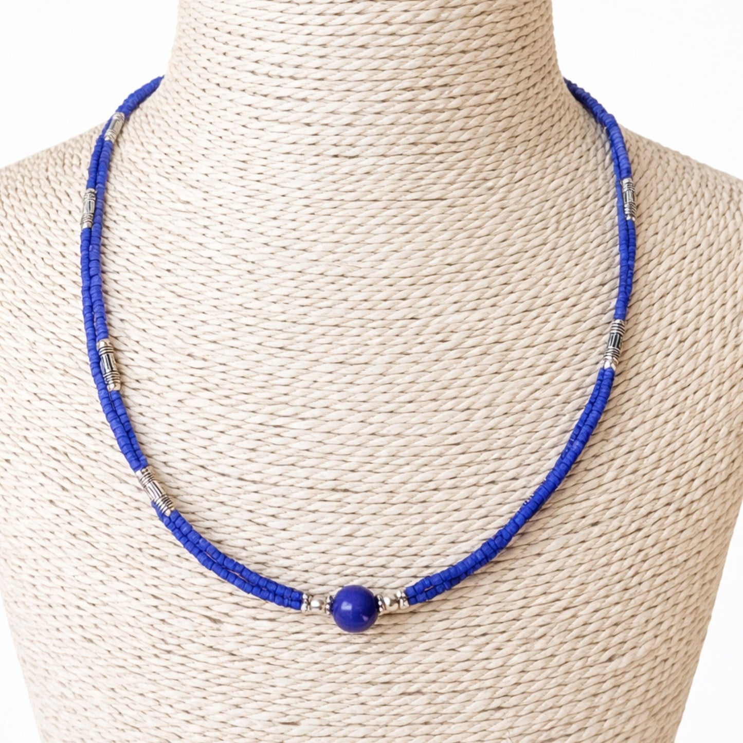 Collar de cuentas azules con bola de lapislázuli y detalles plateados. Estilo moderno y vibrante.