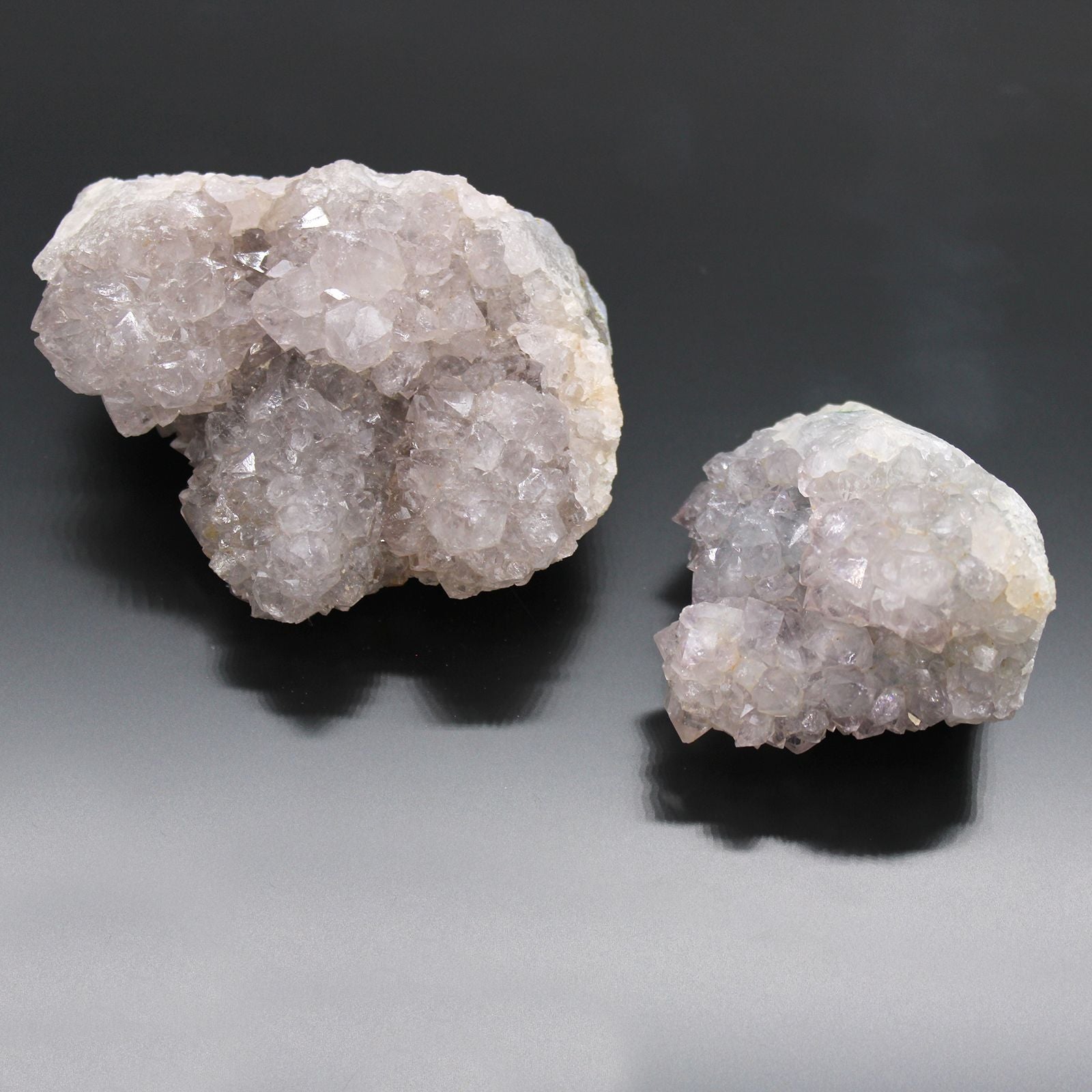 Mineral de cuarzo rosa brillante, dos piezas, textura cristalina, ideal para decoración o coleccionismo.
