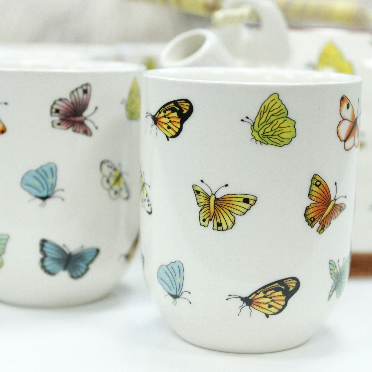 Taza blanca con dibujos de mariposas multicolores, elegante y decorativa, ideal para el hogar o regalos.