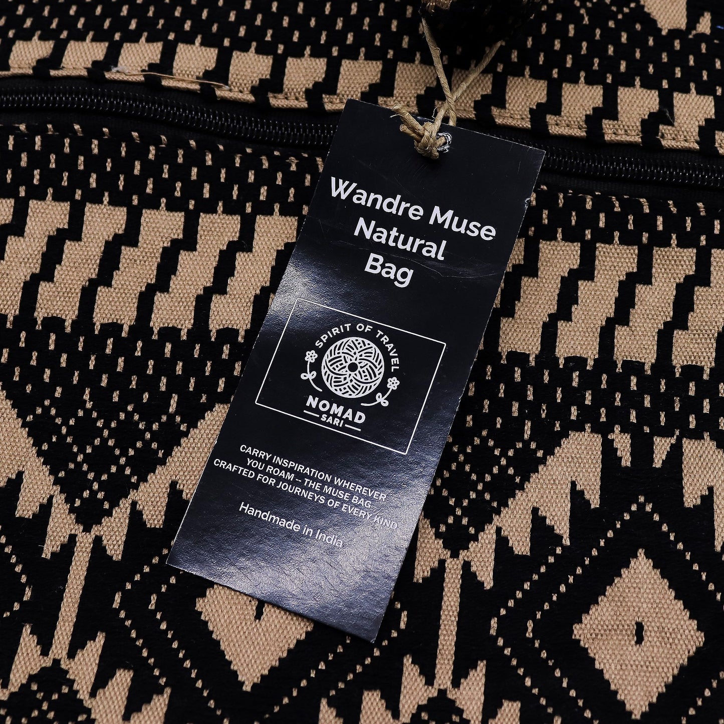Bolsa natural Wandre Muse, hecha a mano en India, con diseño geométrico en negro y beige. Perfecta para viajes.