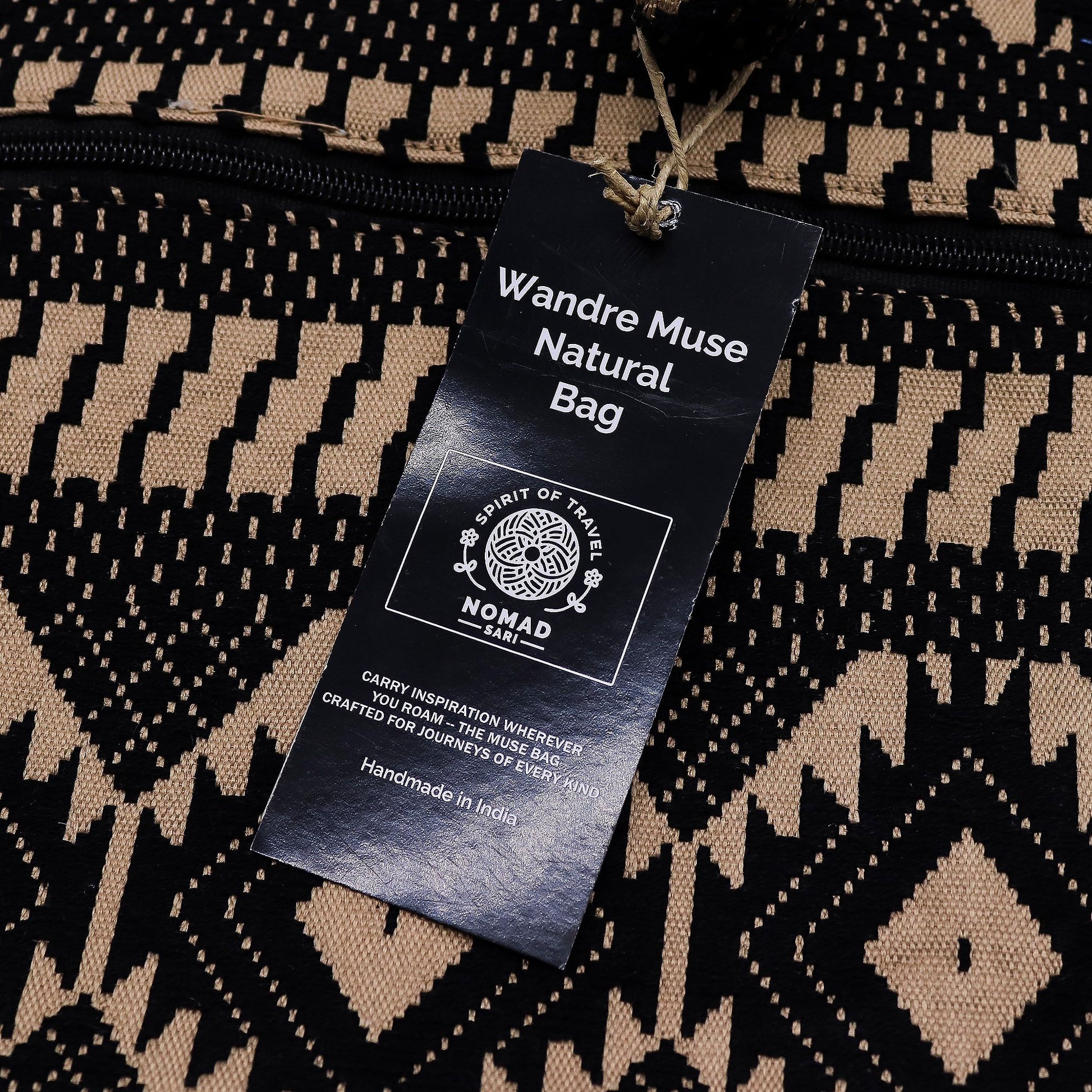 Bolsa natural Wandre Muse, hecha a mano en India, con diseño geométrico en negro y beige. Perfecta para viajes.