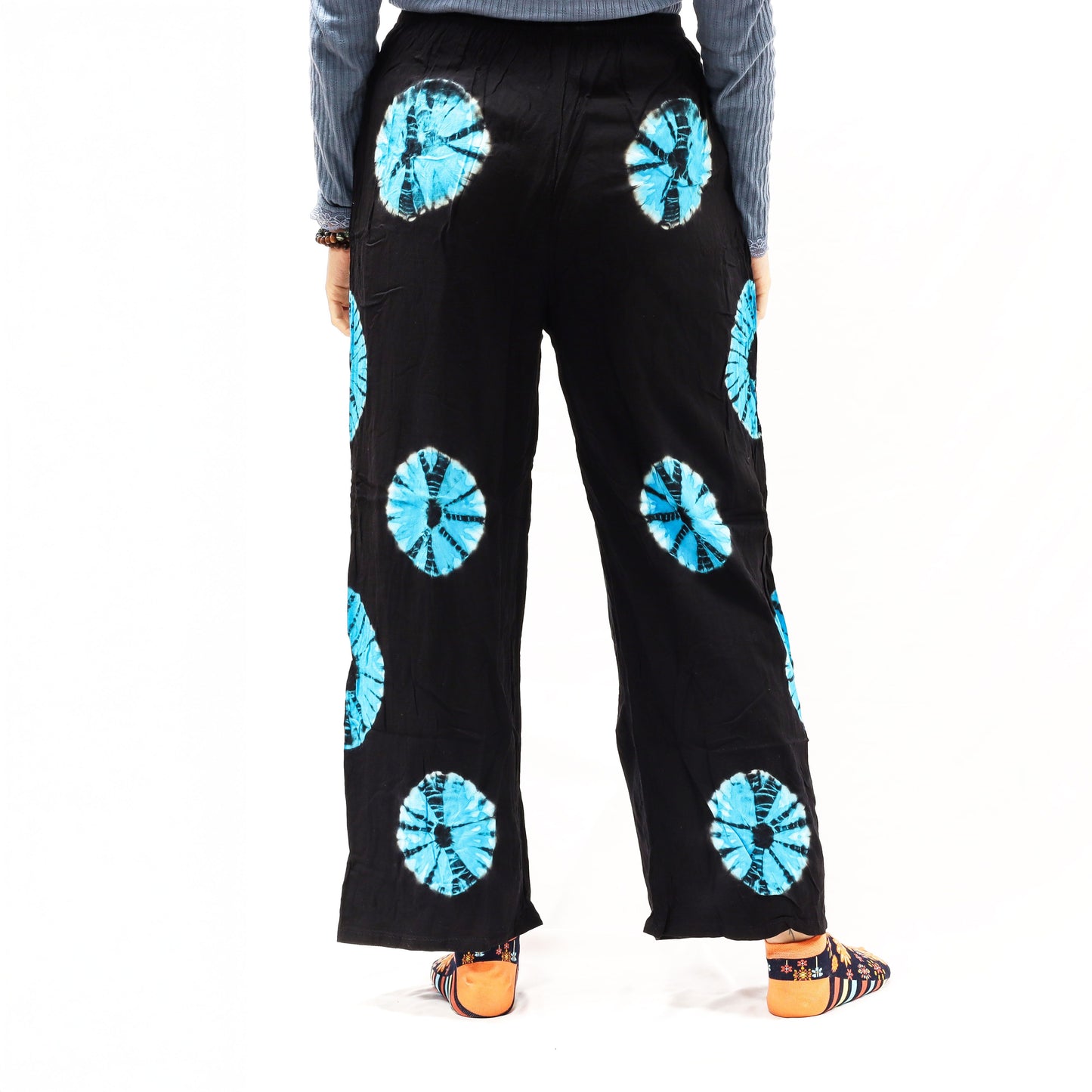 Pantalones de descanso Ancient Wisdom negros con círculos tie-dye azules, corte holgado, cintura elástica y tela ligera.