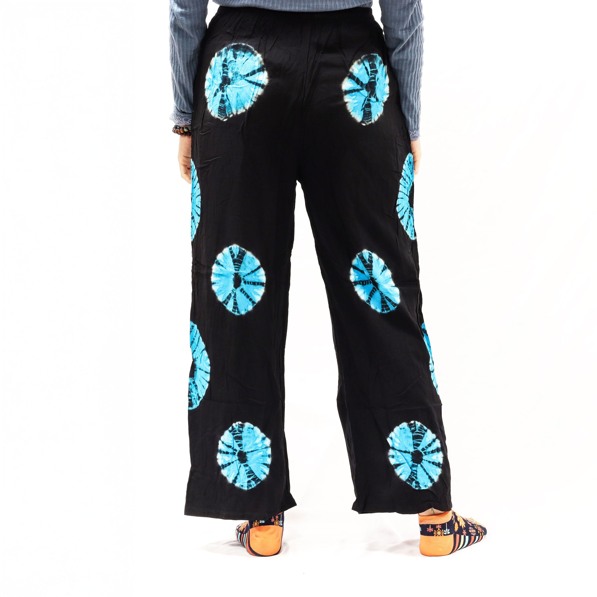 Pantalones de descanso Ancient Wisdom negros con círculos tie-dye azules, corte holgado, cintura elástica y tela ligera.
