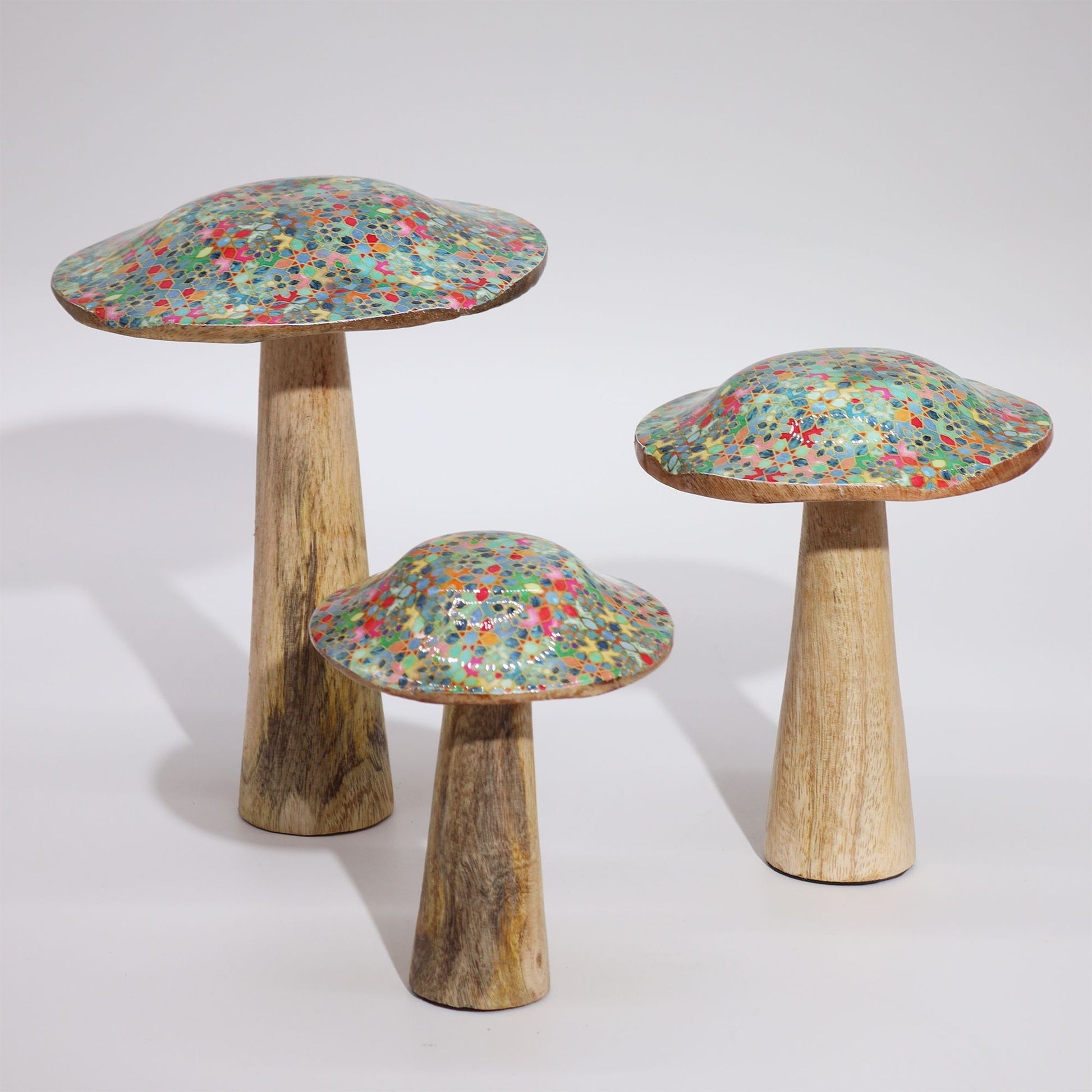 Set de tres setas decorativas de madera, con sombreros en tonos azules y verdes, y bases de madera natural.