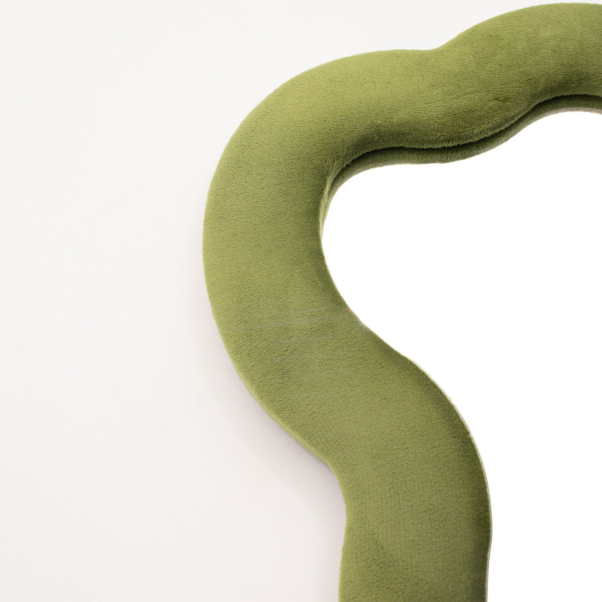 Espejo de pared con borde verde suave y moderno, en forma orgánica y tapizado en tela de terciopelo.