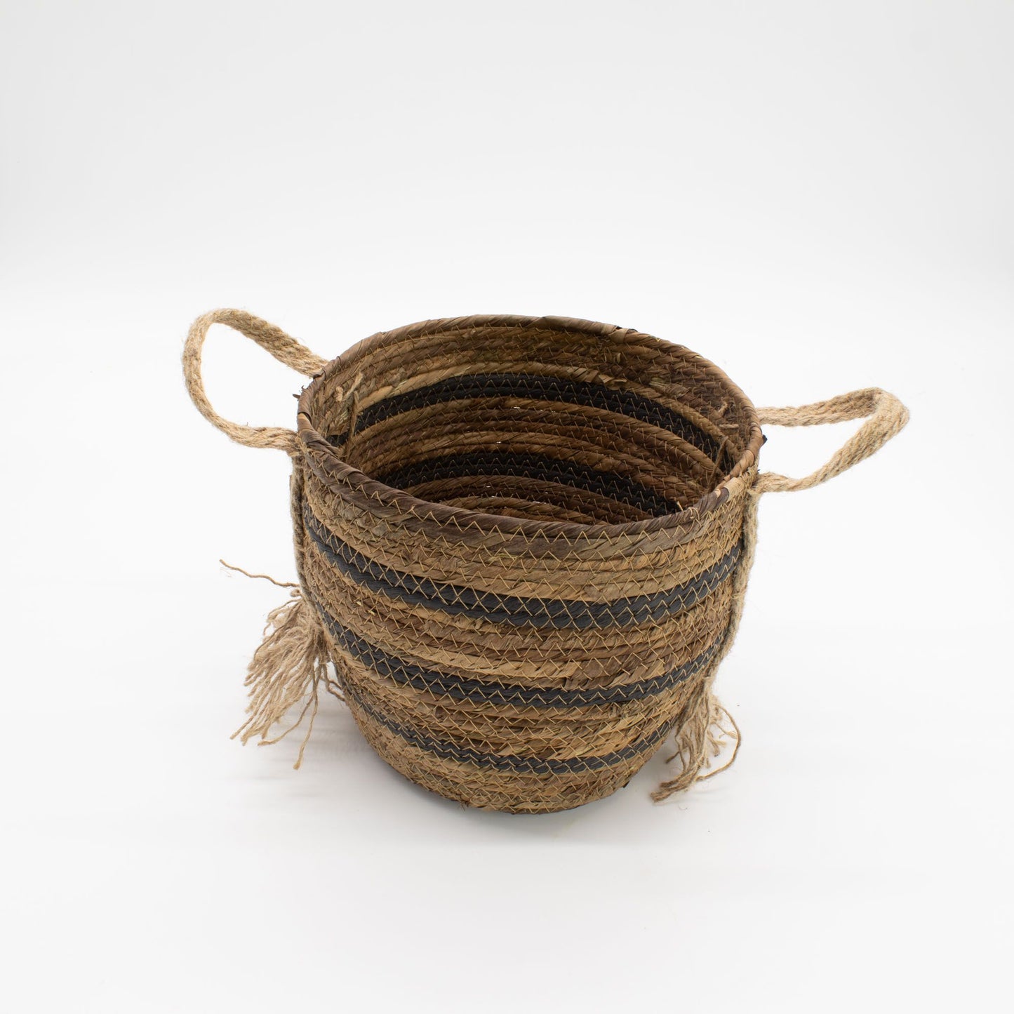 Cesta artesanal de hoja de plátano y pasto marino en tonos marrón natural con asas y detalles decorativos de fibras.