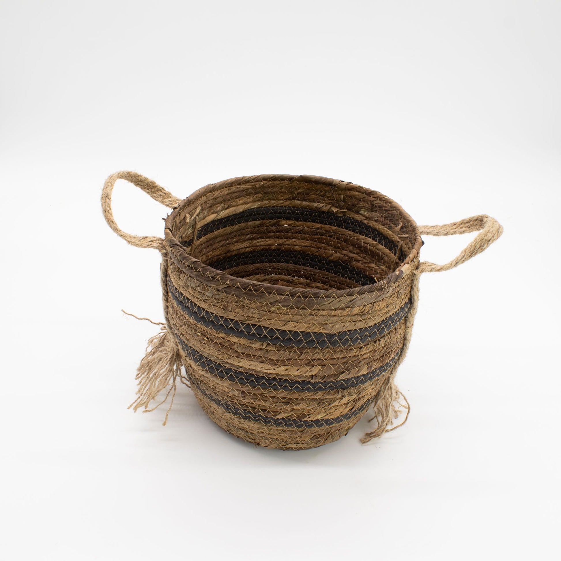 Cesta artesanal de hoja de plátano y pasto marino en tonos marrón natural con asas y detalles decorativos de fibras.