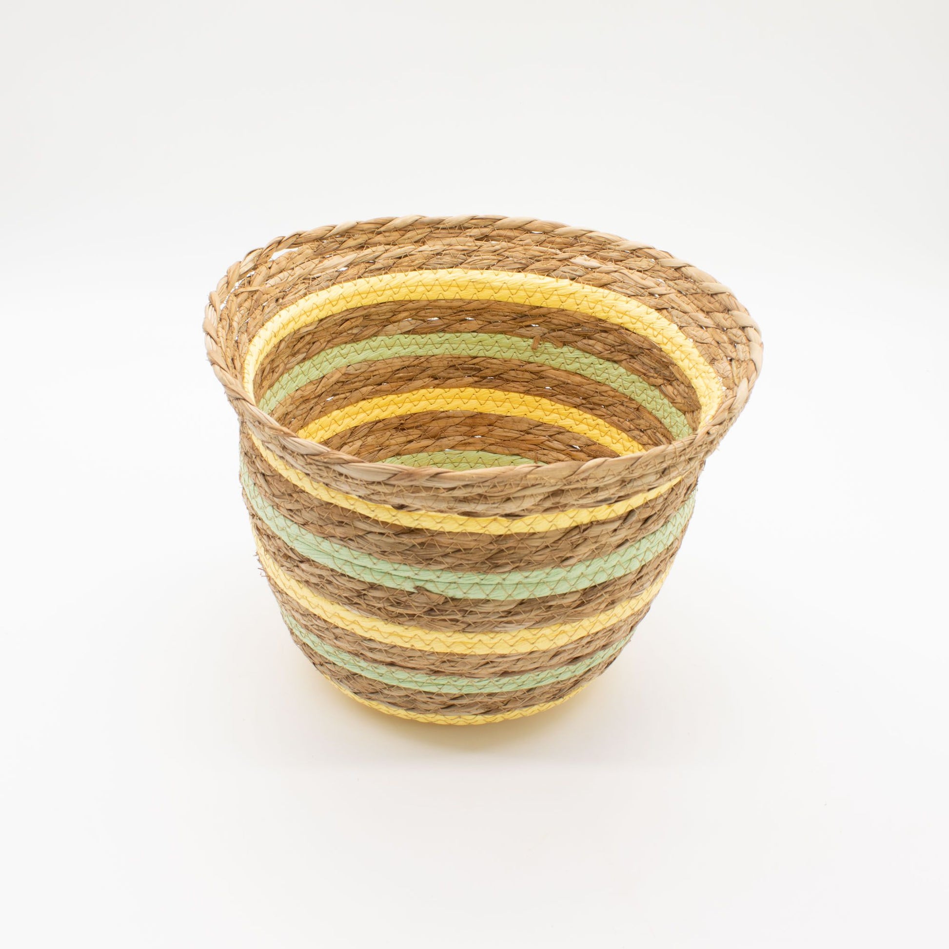 Cesta en forma de jarrón tejida con hierba marina, fibras naturales, detalles en bandas amarillas y verdes.