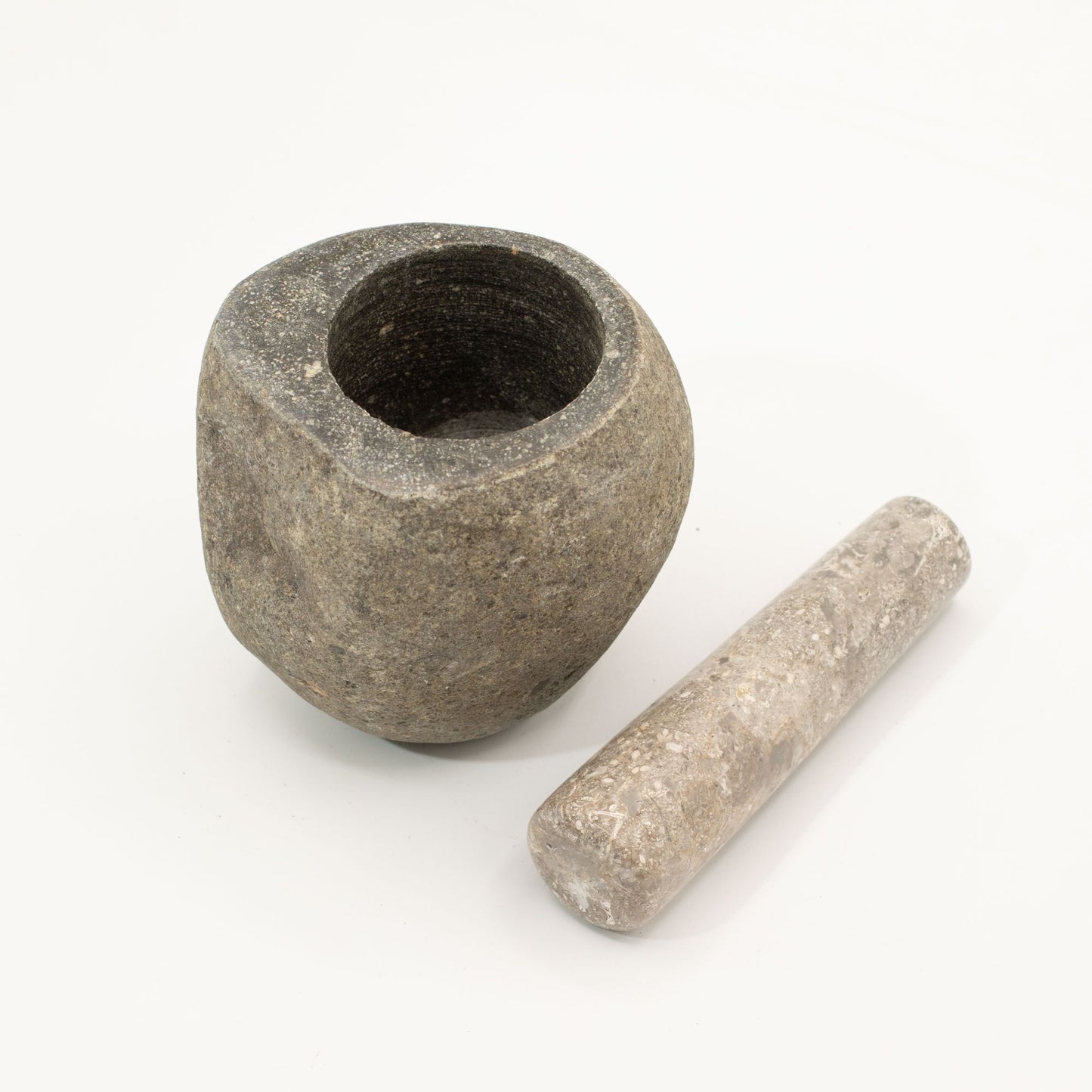 Mortero de piedra gris con mano de triturar, estilo rústico y acabado natural, ideal para cocina.