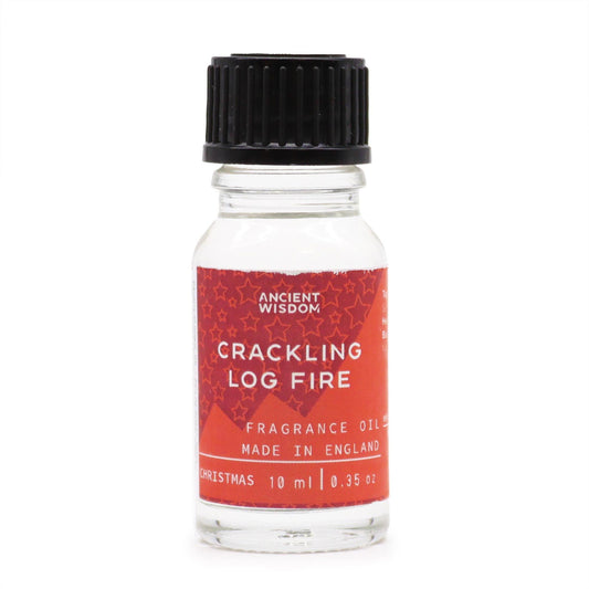 Frasco pequeño de vidrio transparente con aceite aromático, tapón negro y etiqueta roja con estrellas y texto blanco.