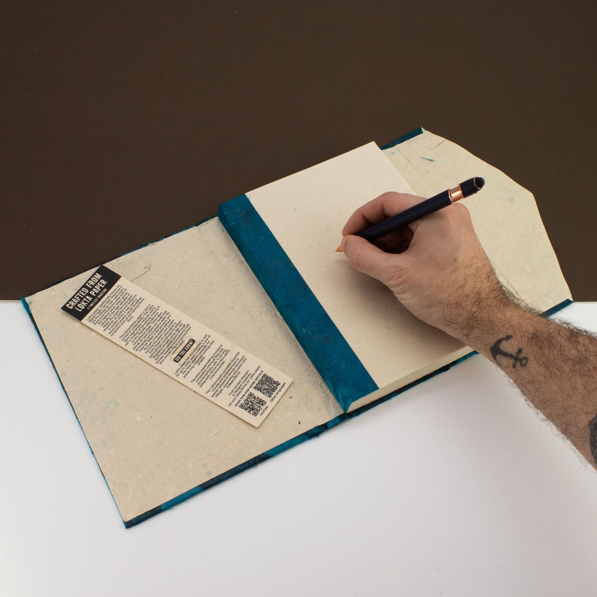 Cuaderno de papel reciclado con tapa azul y marcador, estilo moderno, eco-amigable y minimalista.
