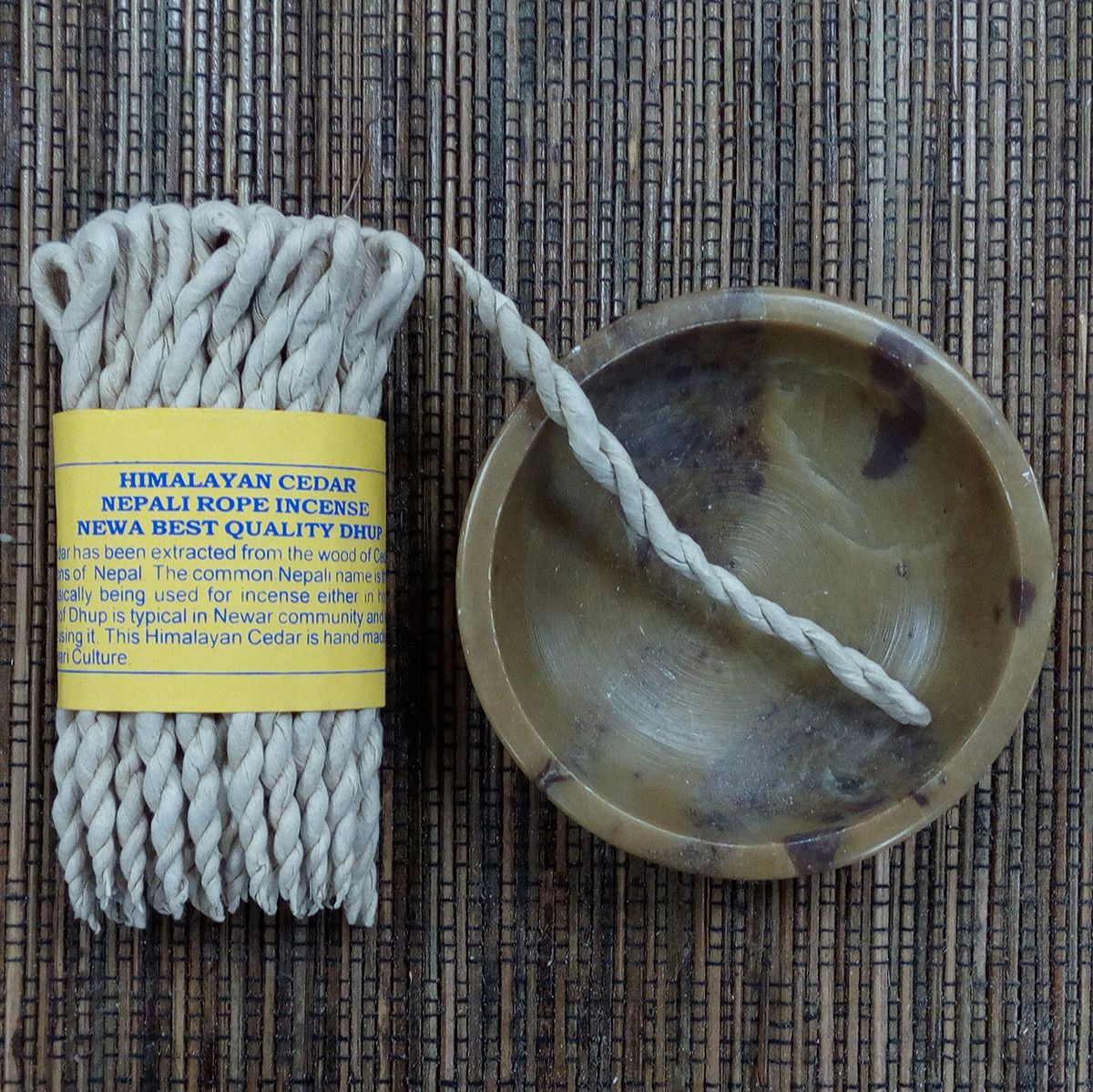 Incienso de cuerda de cedro himalayo, color beige, acompañado de soporte redondo de cerámica, estilo artesanal.