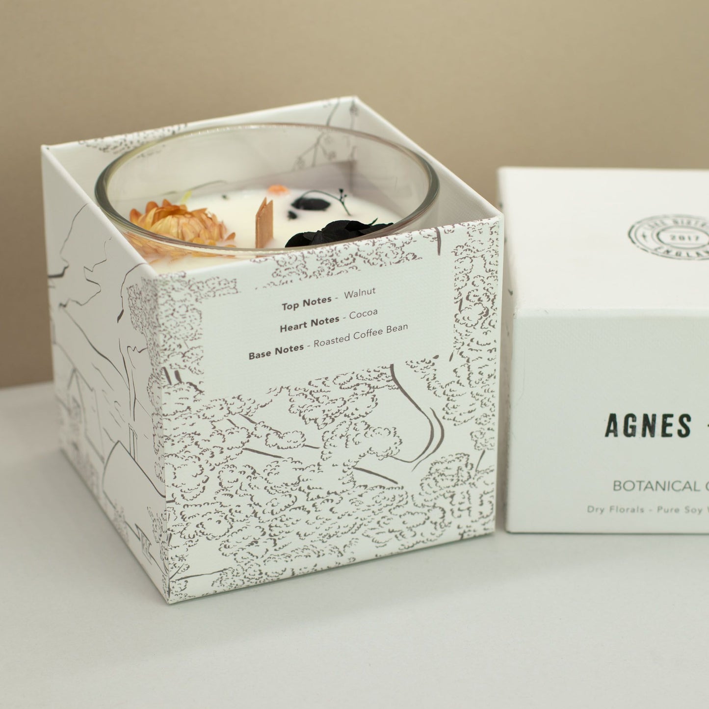 Vela de soja en caja blanca con notas de nuez, cacao y café, decorada con flores secas.
