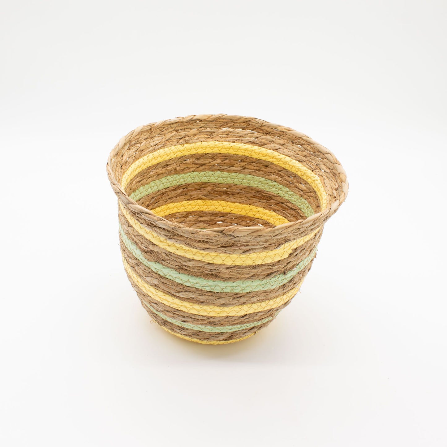 Cesta artesanal de hierba marina en forma de jarrón, con fibras naturales tejidas en rayas amarillas y verdes.